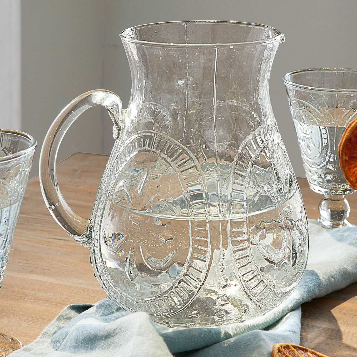 Dzbanek Pépin Przezroczysty szklany dzbanek z ozdobnym wzorem na drewnianym stole z serwetką