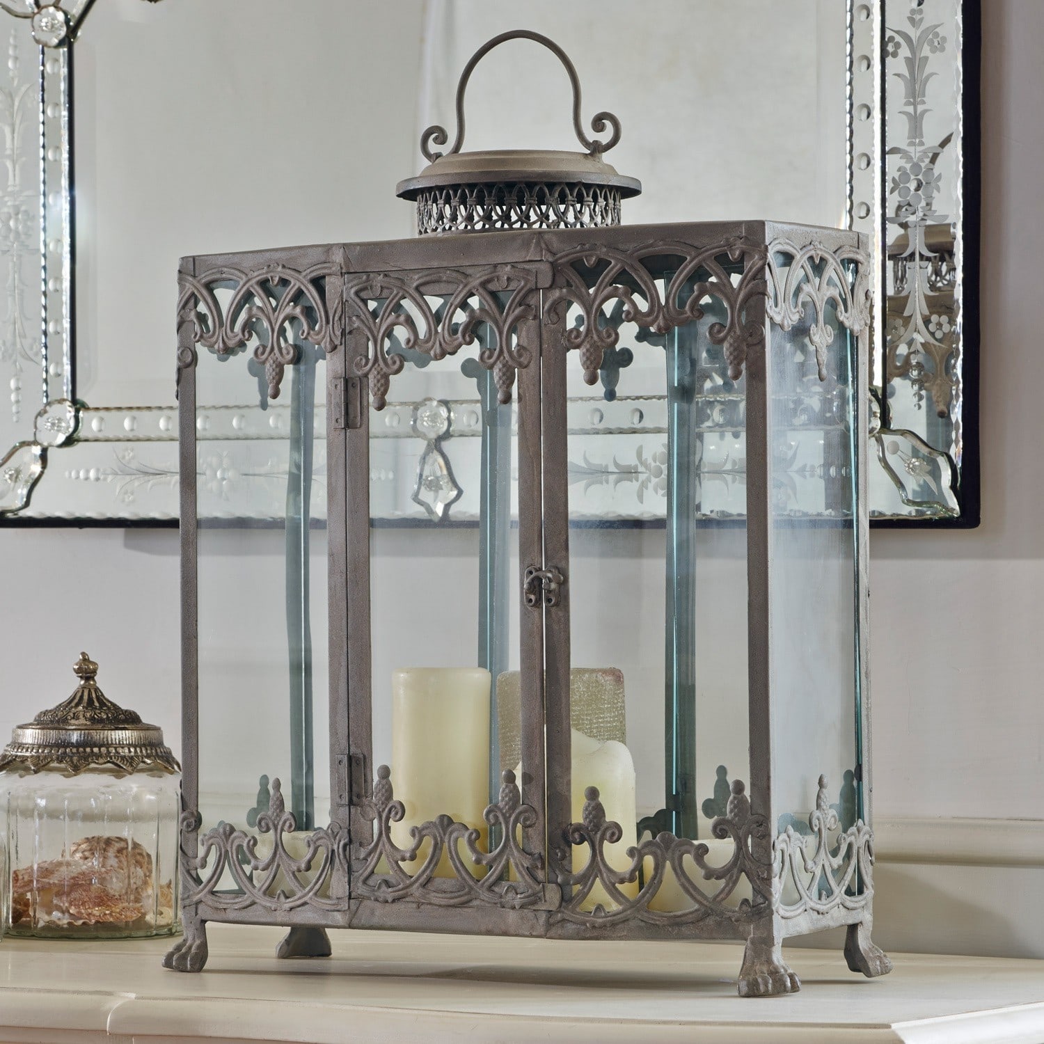 Lampion Canousse Metalowa latarnia dekoracyjna z szklanymi panelami i świecami w kolorze kremowym na stoliku