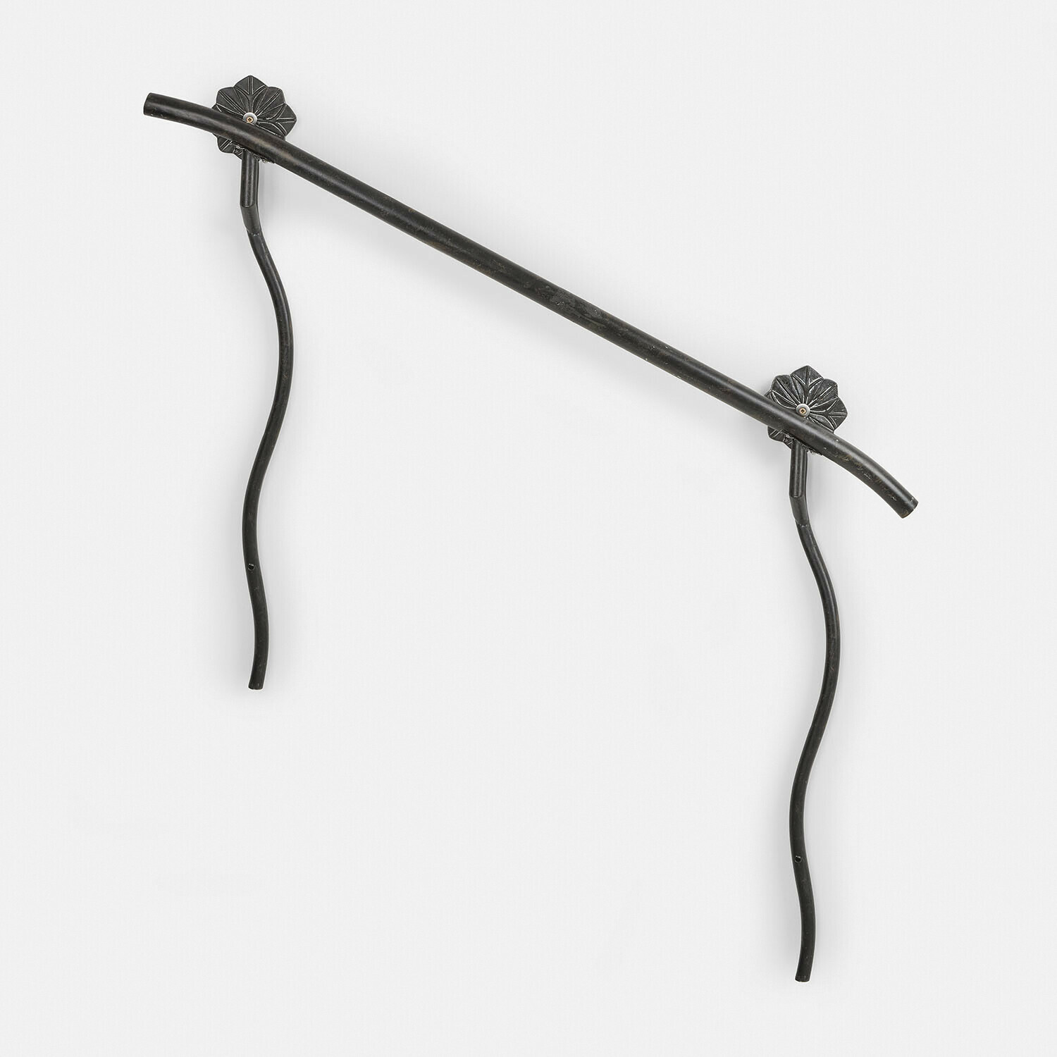 Czarny metalowy uchwyt ścienny z falistymi nogami i ozdobnymi mocowaniami do dekoracji wnętrz