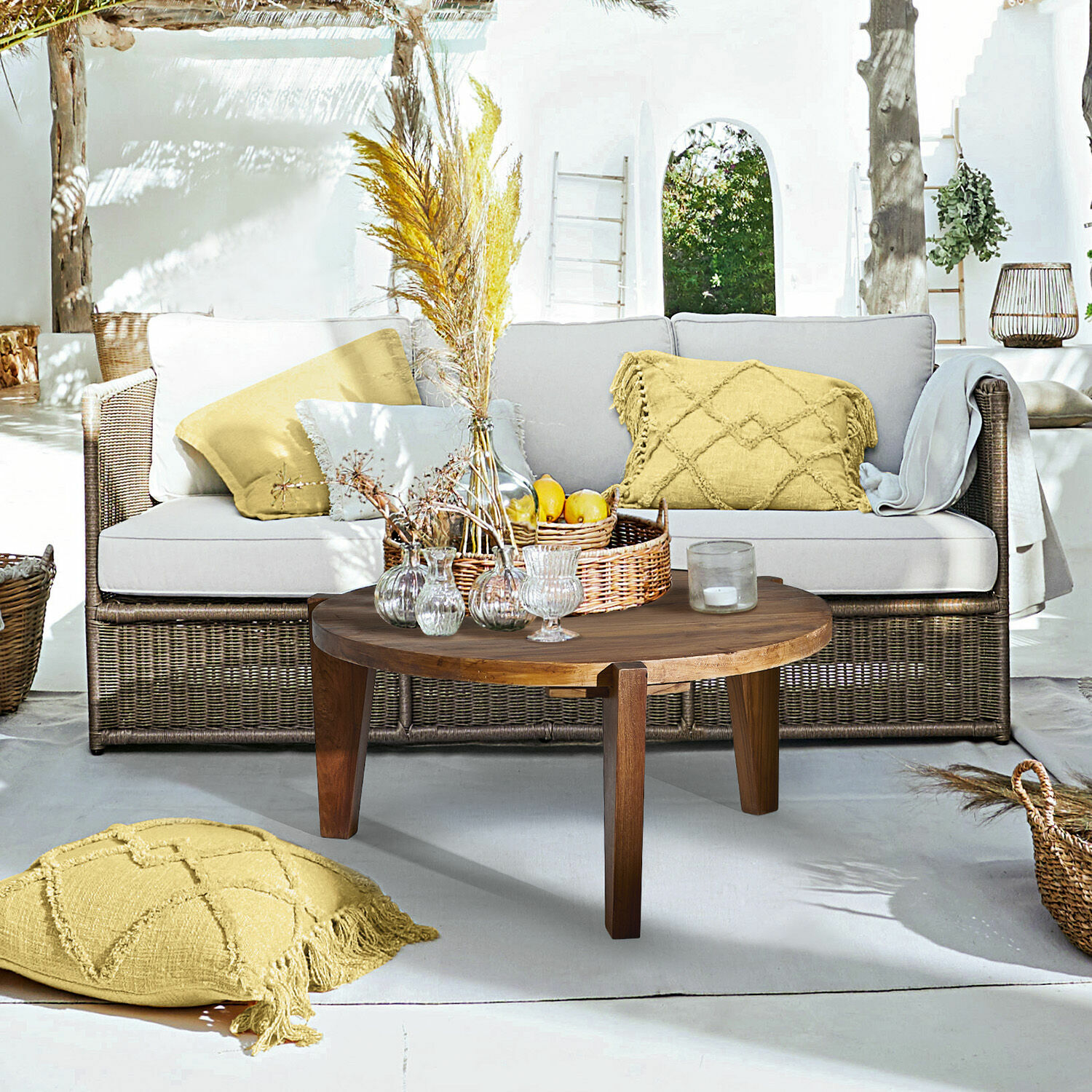 Sofa Lesmont Salon z wiklinową sofą i jasnoszarymi poduszkami oraz drewnianym stolikiem kawowym na tarasie