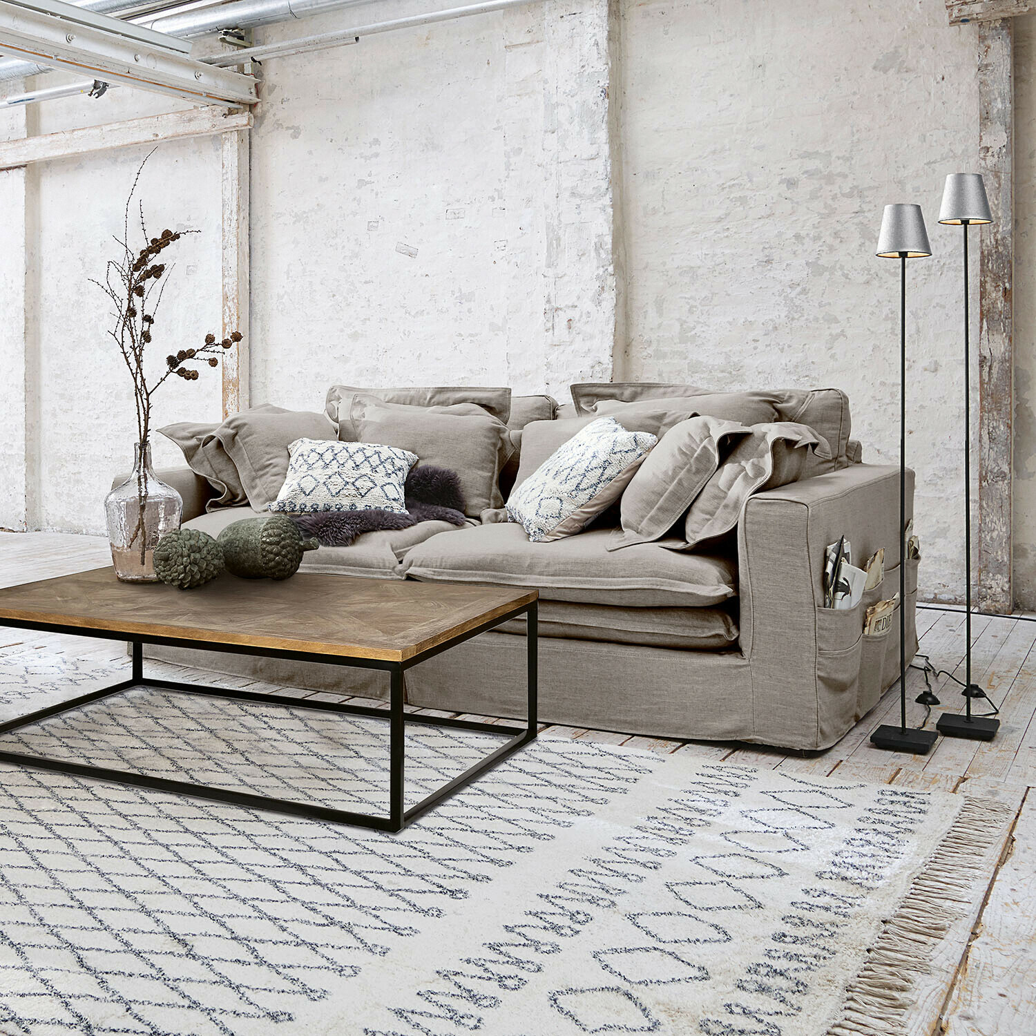 Sofa Terell Szara sofa z tkaniny z poduszkami i drewniany stolik kawowy na jasnym dywanie w nowoczesnym salonie