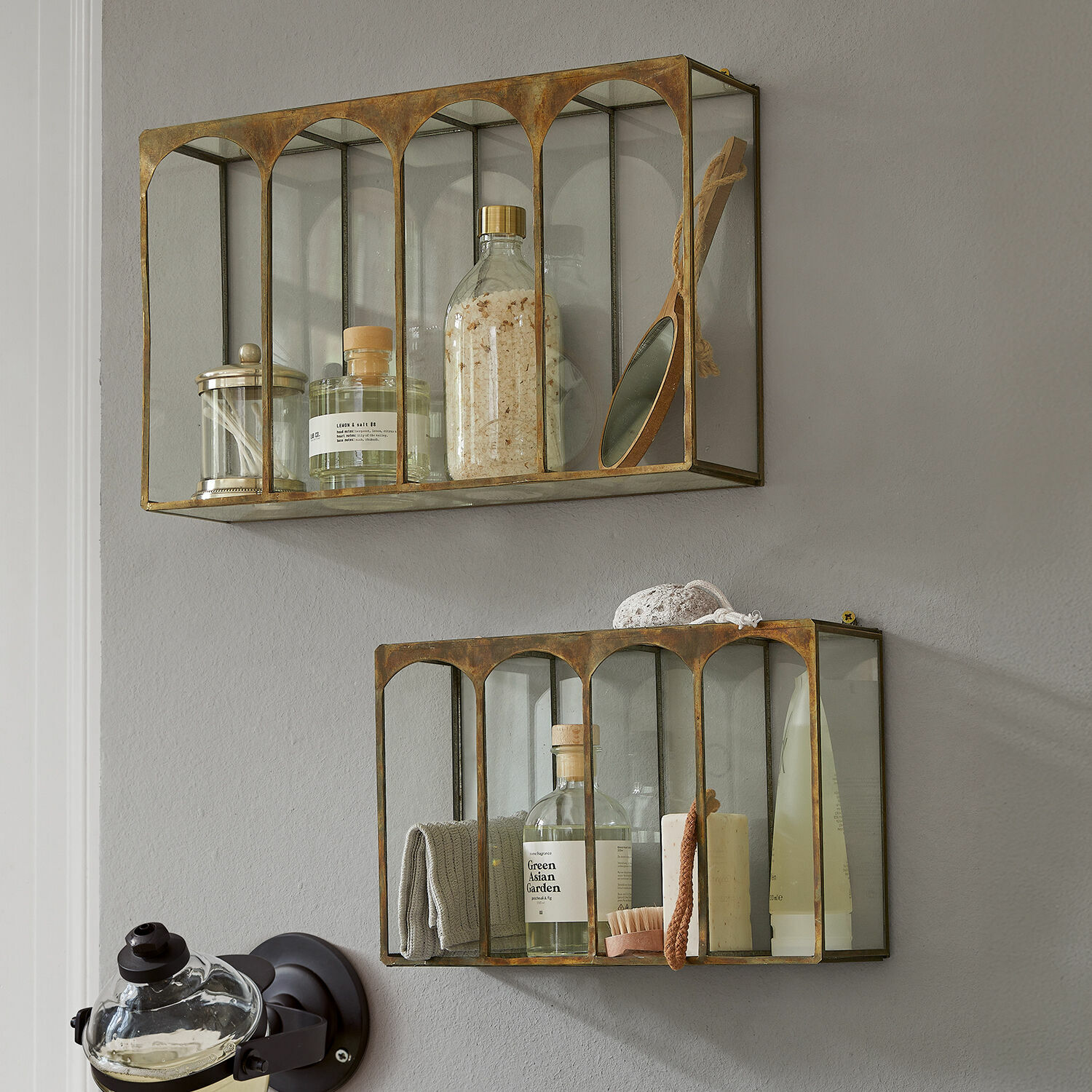 Zestaw dwóch szklanych półek ściennych z metalową ramą w kolorze mosiądzu do przechowywania kosmetyków