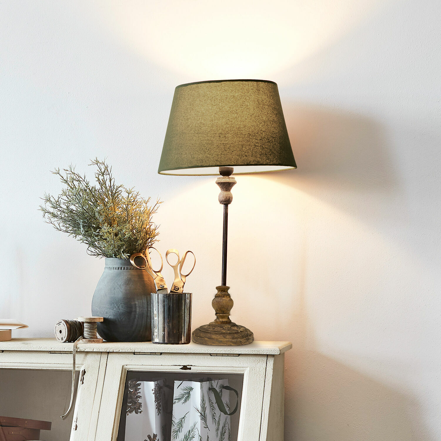 Lampa stołowa Karlora Lampka stołowa z zielonym abażurem i drewnianą podstawą na białej komodzie z dekoracją