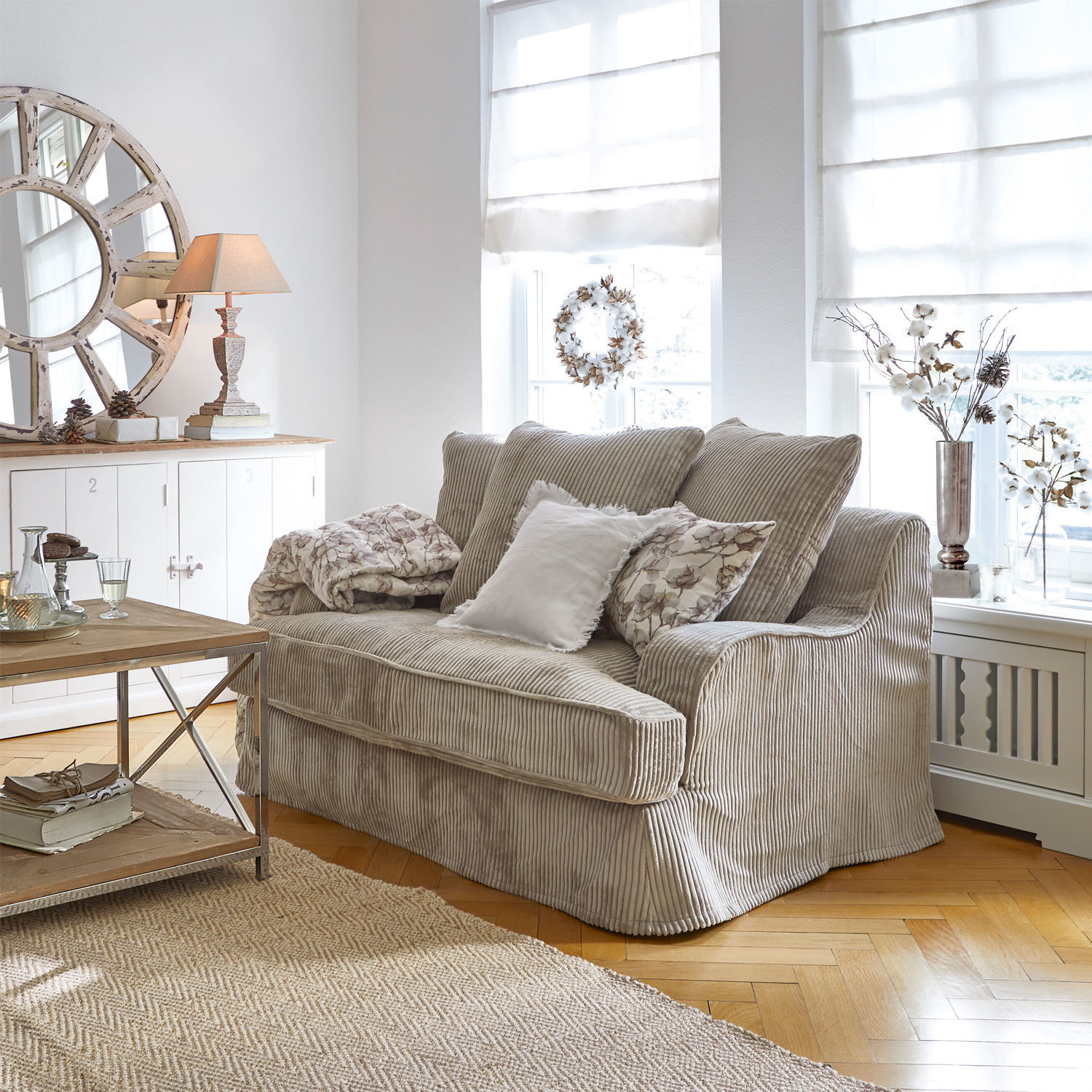Sofa Monaco Beżowa sofa z miękkiego sztruksu w jasnym salonie z dekoracjami i dywanem z juty