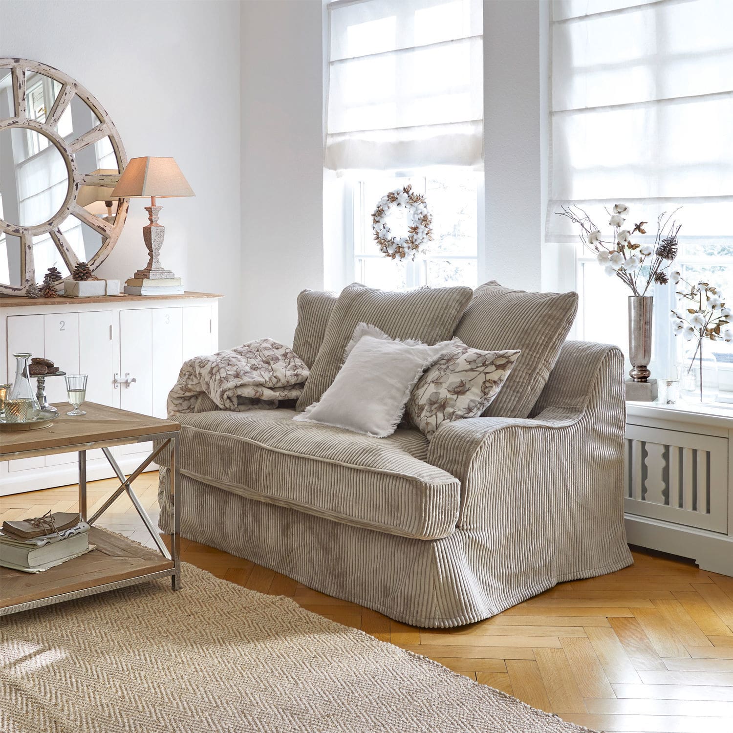Sofa Monaco Beżowa sofa z miękkiego sztruksu w jasnym salonie z dekoracjami i dywanem z juty
