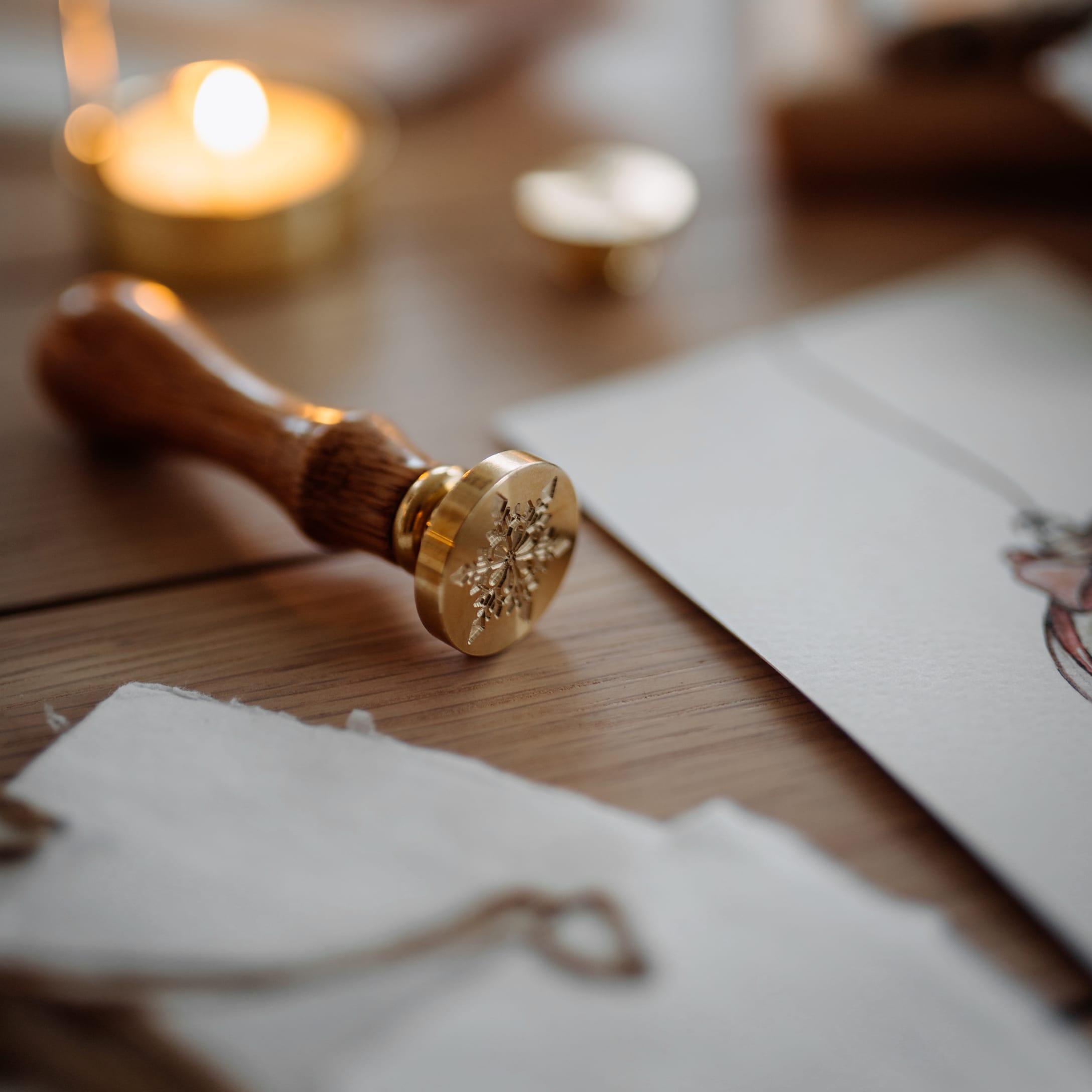 Stempel do pieczęci z mosiądzu i drewna z motywem śnieżynki na drewnianym stole do pakowania prezentów