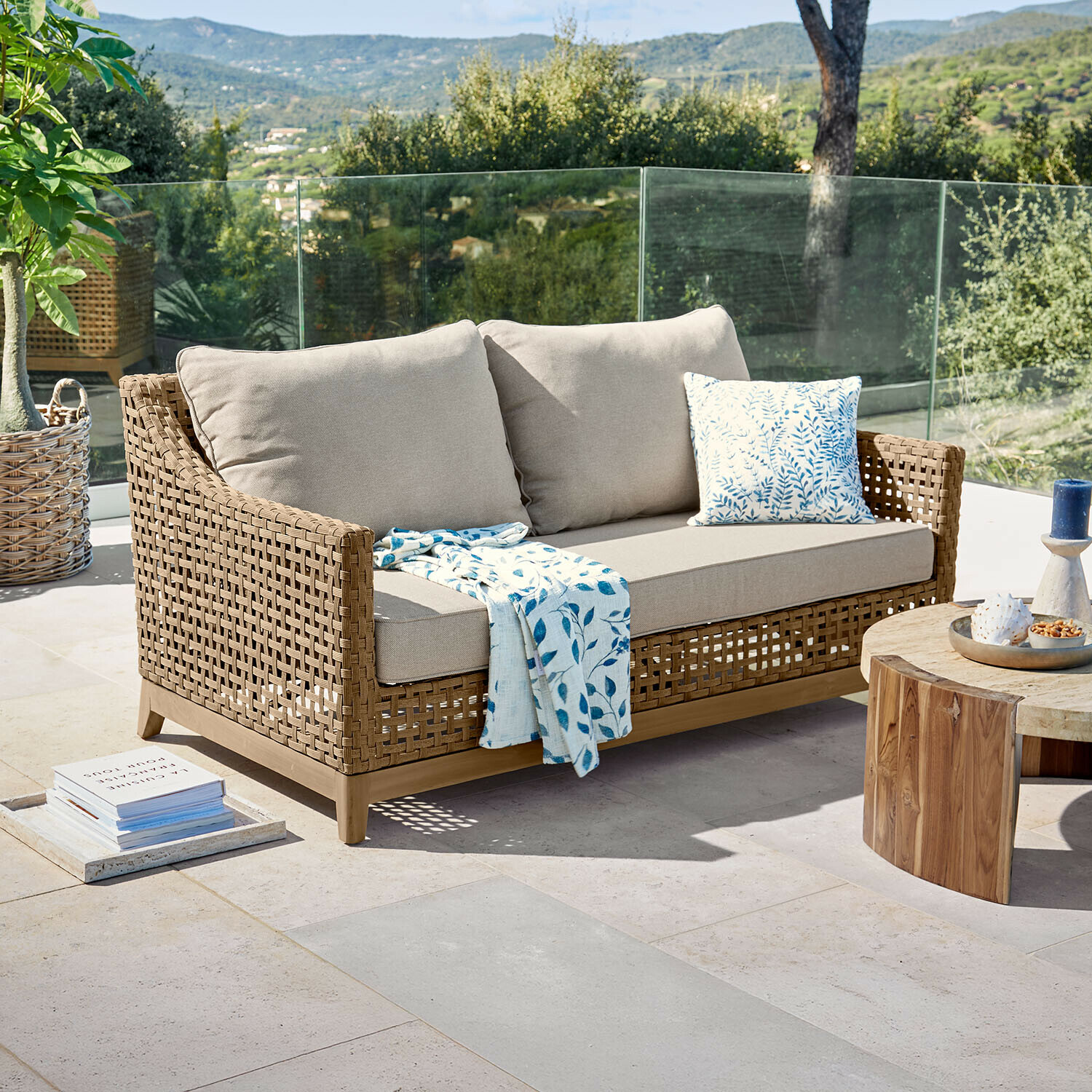 Sofa Isolara Sofa ogrodowe z plecionego rattanu w kolorze naturalnym z beżowymi poduszkami i niebieskim kocem