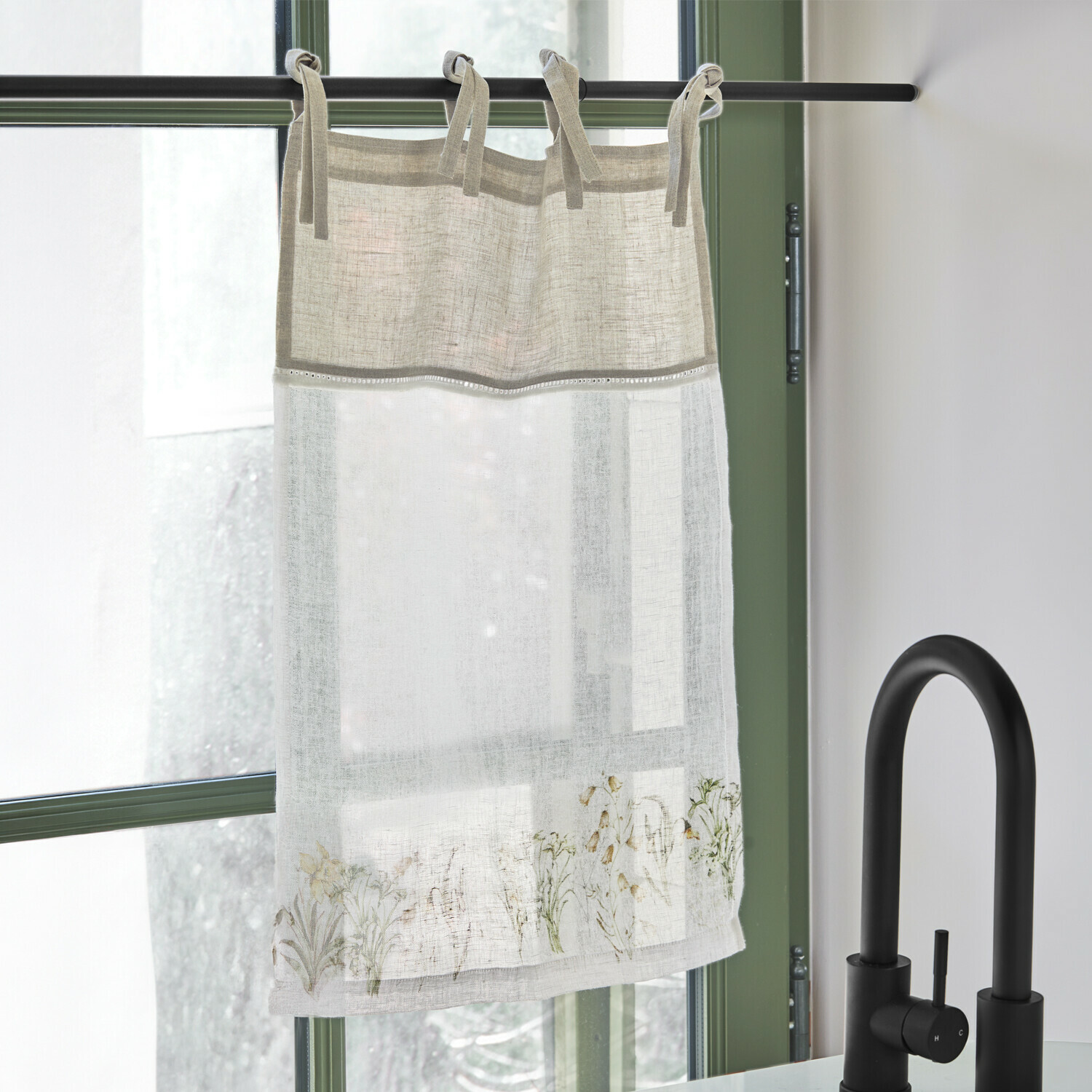 Zazdrostka Lozere Lniana firanka w beżowym i białym kolorze z delikatnym kwiatowym wzorem, zawieszona na czarnej karniszu