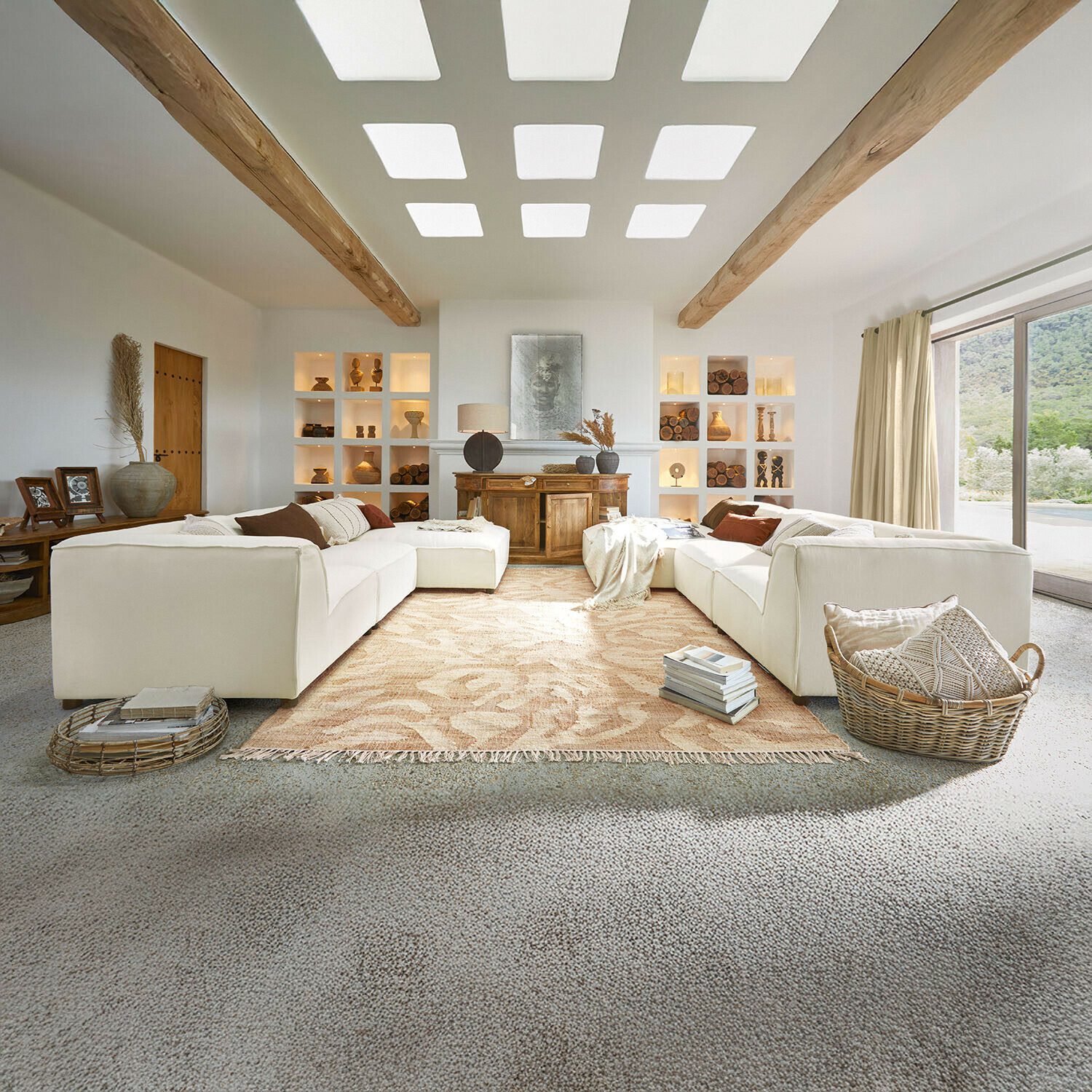Przestronny salon z białą sofą, drewnianymi belkami i dekoracjami w naturalnych kolorach, dywanem i dużym oknem