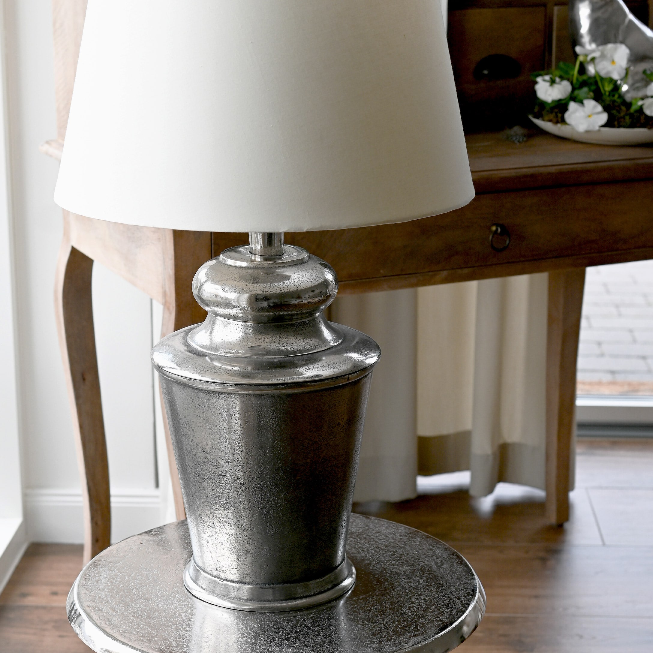 Lampa stołowa z metalową srebrną podstawą i białym abażurem, dekoracja wnętrza w stylu vintage