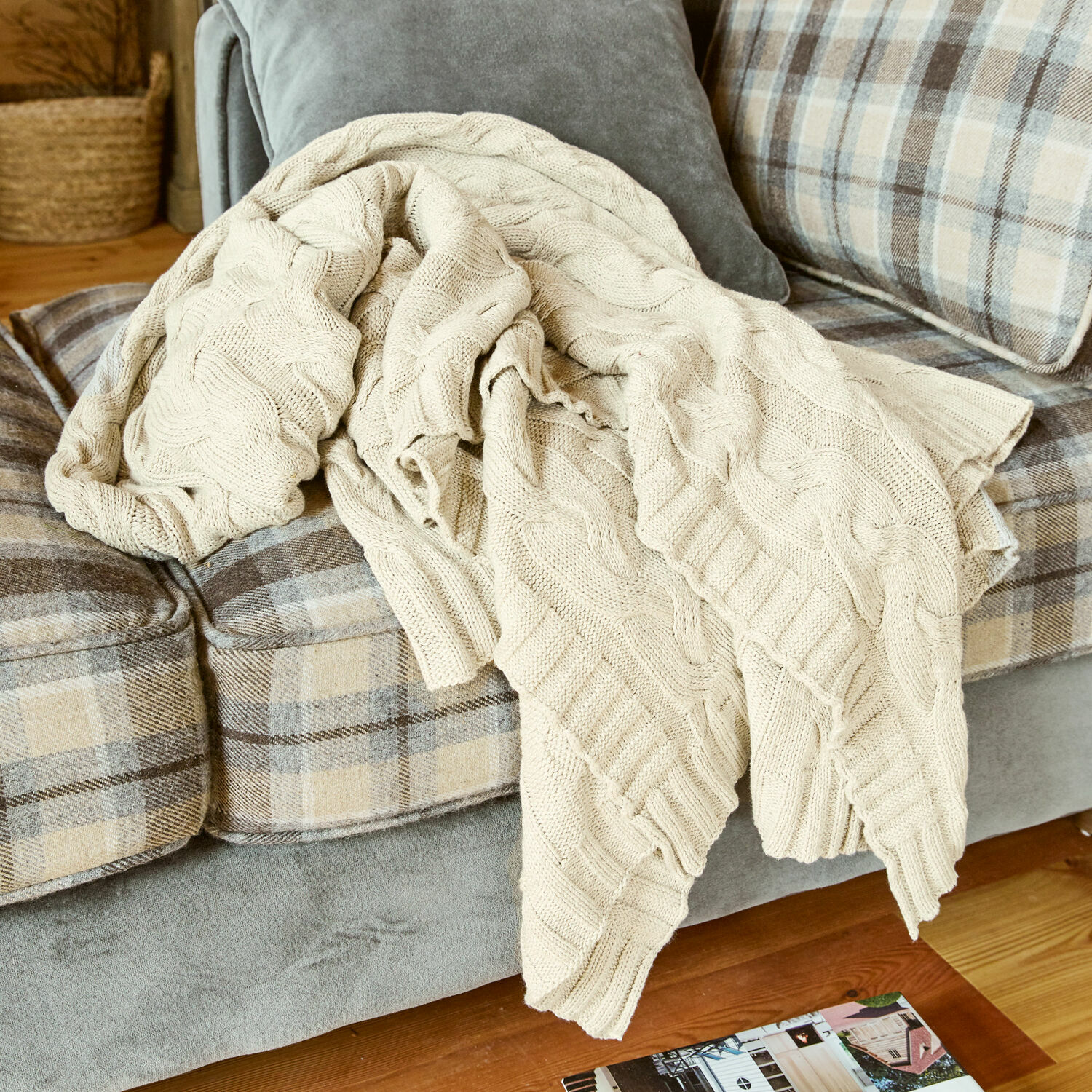 Pled Arnhem Beżowy dziergany koc z bawełny na szarej i beżowej kratkowanej sofie w salonie