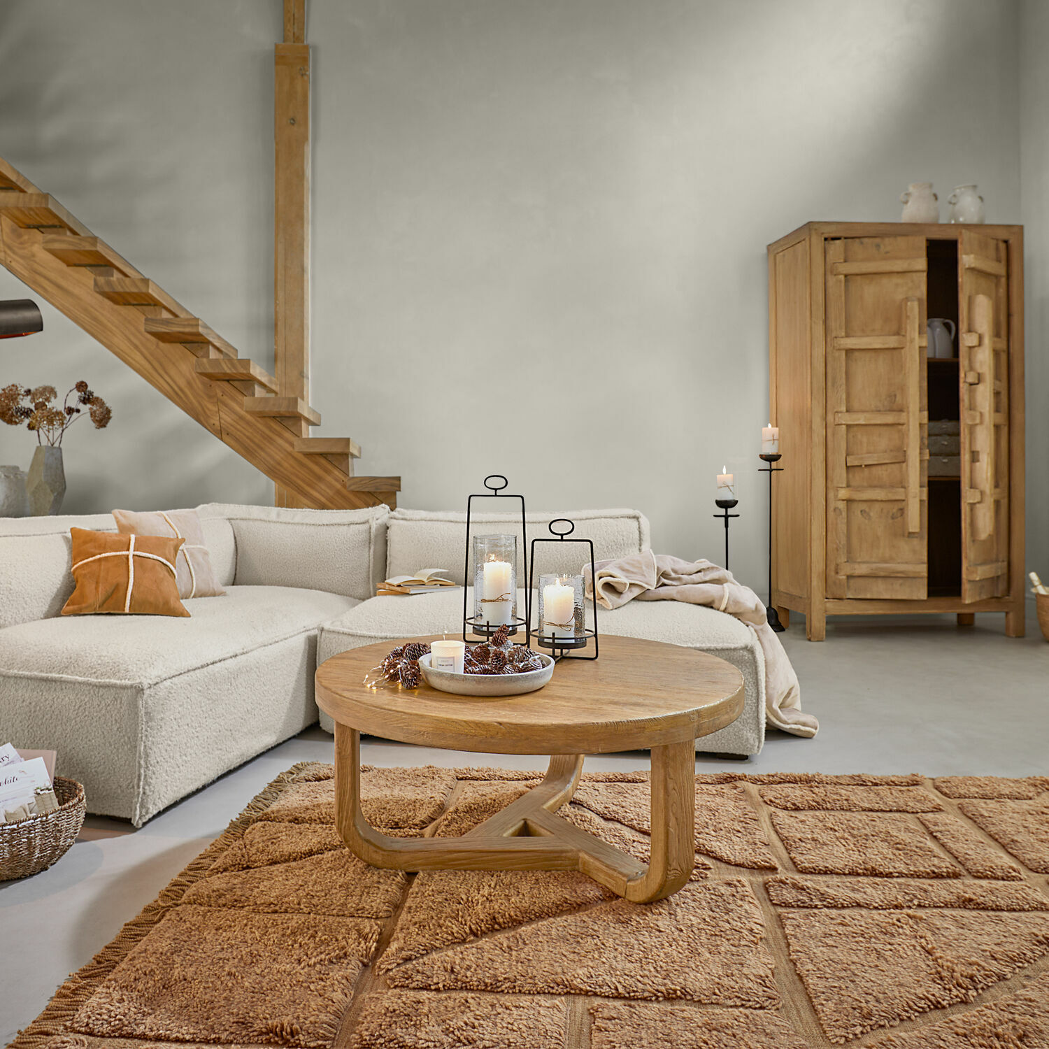 Nowoczesny salon z beżową sofą, drewnianym stolikiem kawowym i dywanem w ciepłym odcieniu brązu