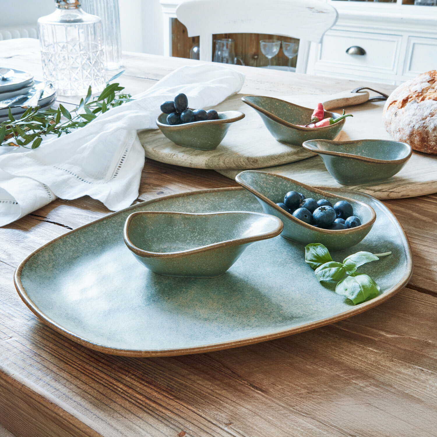 Miseczki do serwowania, zestaw 6 szt. Biarré Zestaw ceramicznych miseczek i talerza w zielonym kolorze na drewnianym stole z owocami i chlebem