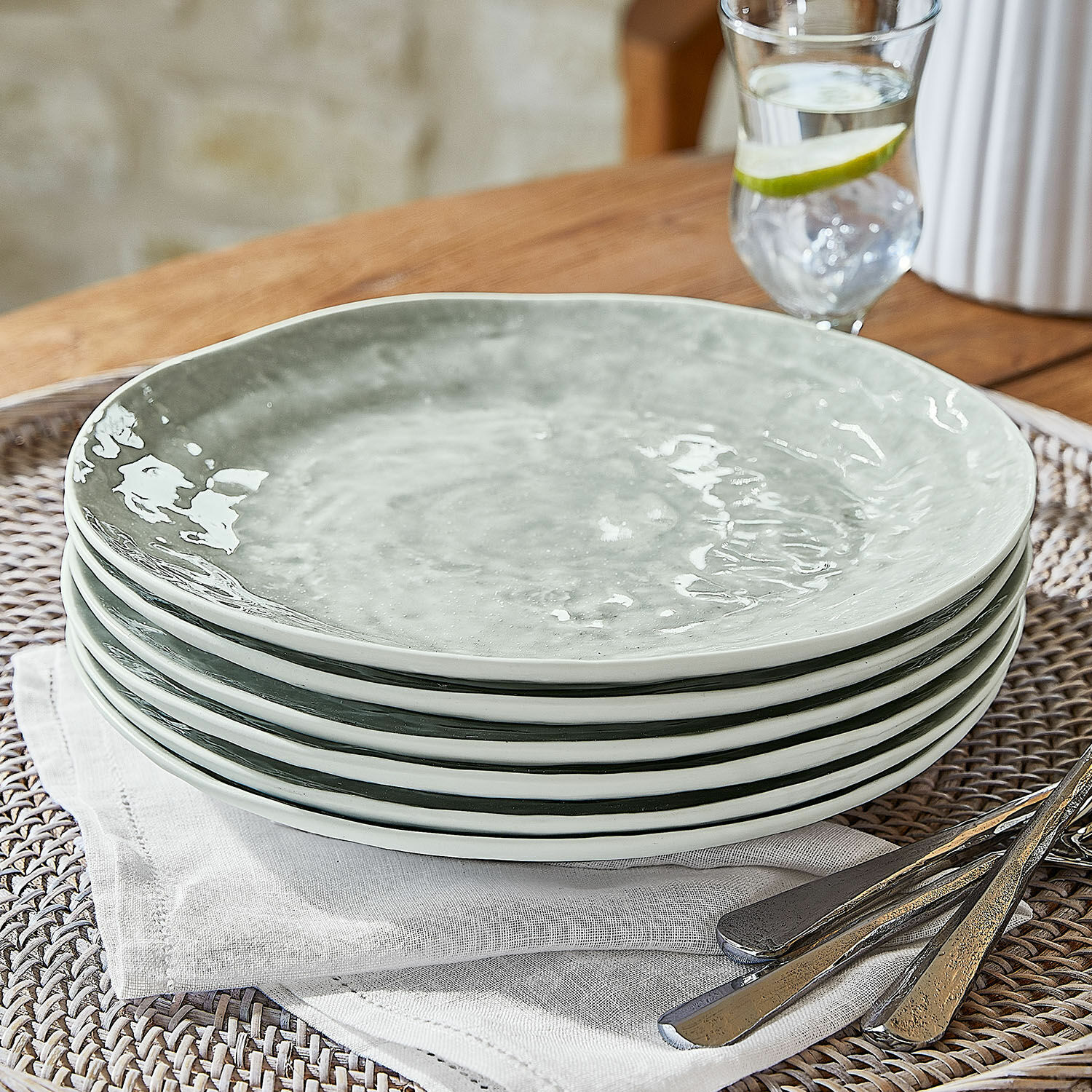 Zestaw 6 talerzy Braganza Zestaw sześciu ceramicznych talerzy w szarym kolorze na lnianej serwetce z metalowymi sztućcami
