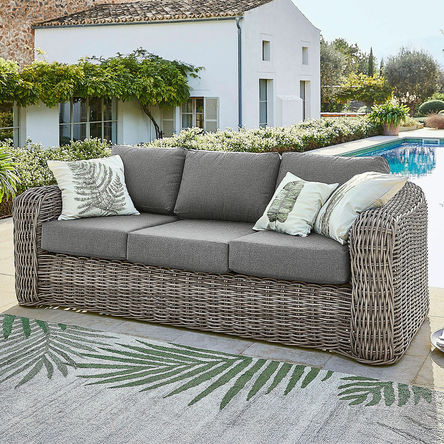 Sofa Upminster Sofa ogrodowe z plecionki w kolorze szarym z szarymi poduszkami i dekoracyjnymi poduszkami z motywem liści