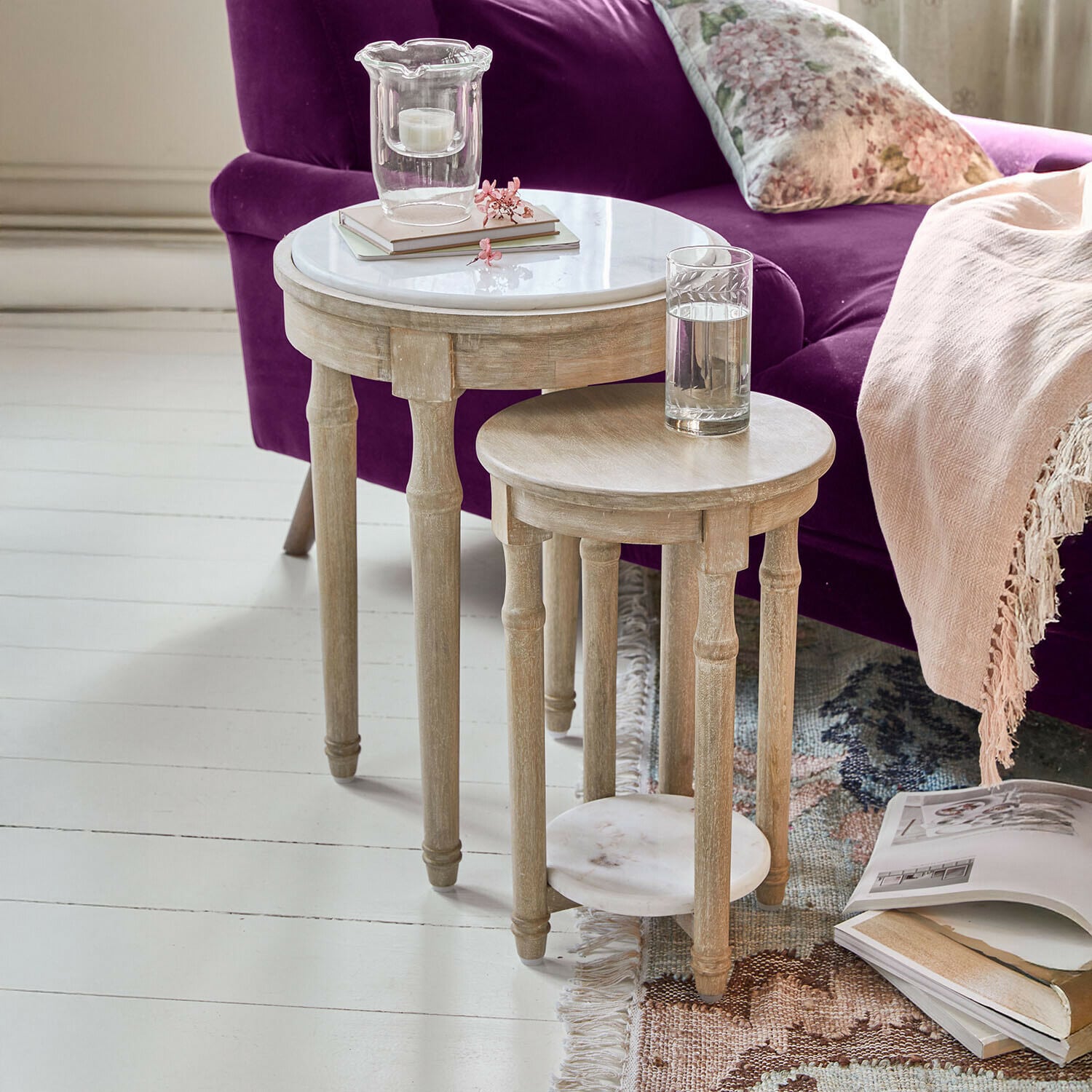 Zestaw dwóch okrągłych stolików z drewna i marmurowymi blatami w jasnym kolorze do salonu