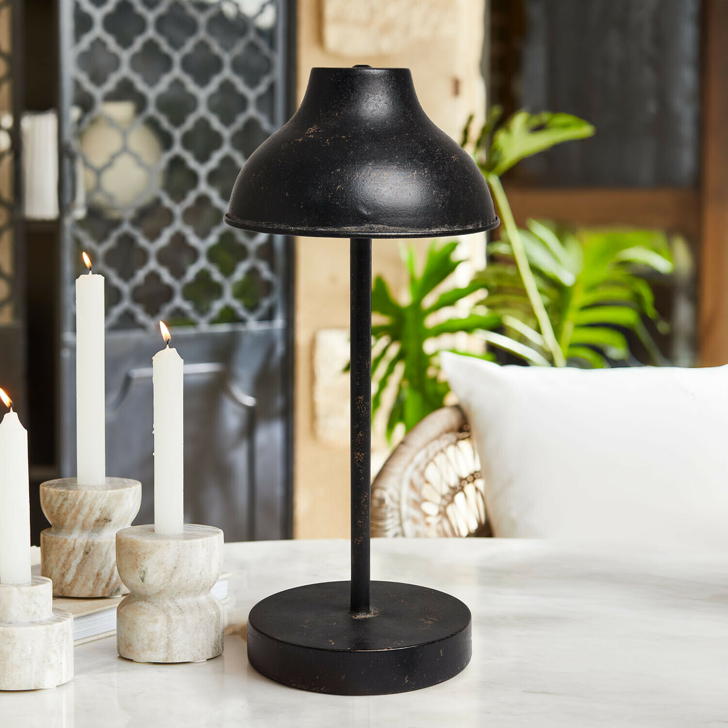 Lampa stołowa LED z baterią Henvique Czarna metalowa lampa stołowa z postarzaną powierzchnią na marmurowym stole w salonie