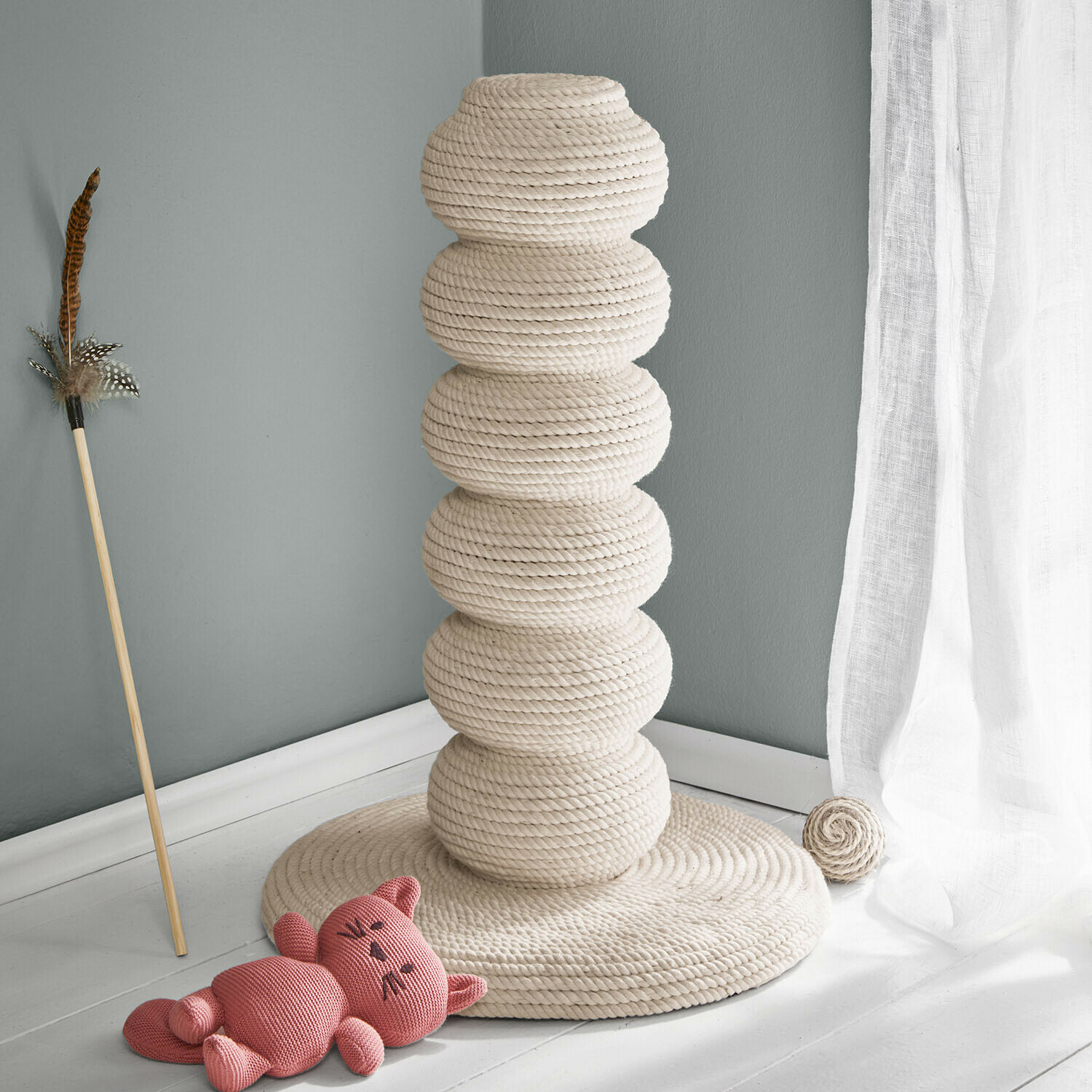 Kremowy drapak dla kota z naturalnej liny z zabawką i różowym pluszowym kotem na podłodze