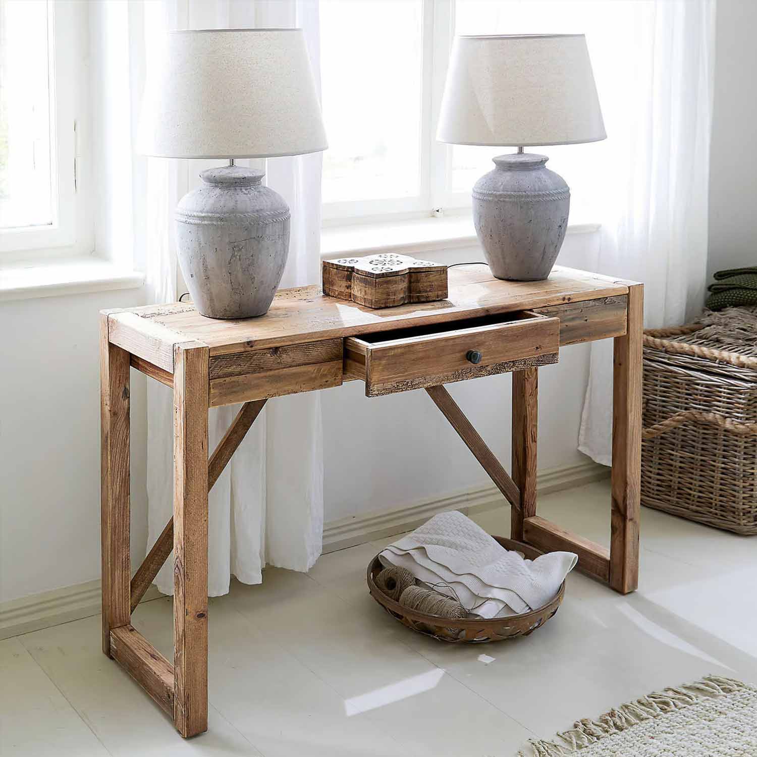 Rustykalne drewniane biurko z szufladą i dwiema szarymi lampami ceramicznymi w jasnym pokoju