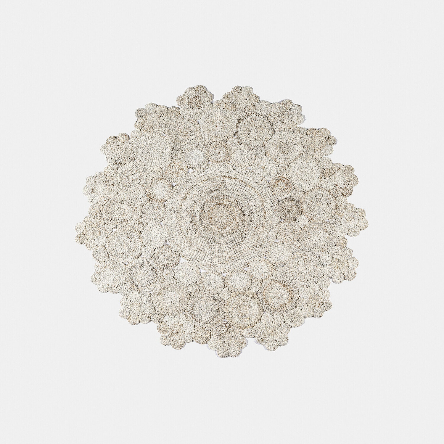 Okrągły dywan z naturalnego materiału w jasnym beżowym kolorze z kwiatowym wzorem, dekoracja wnętrz