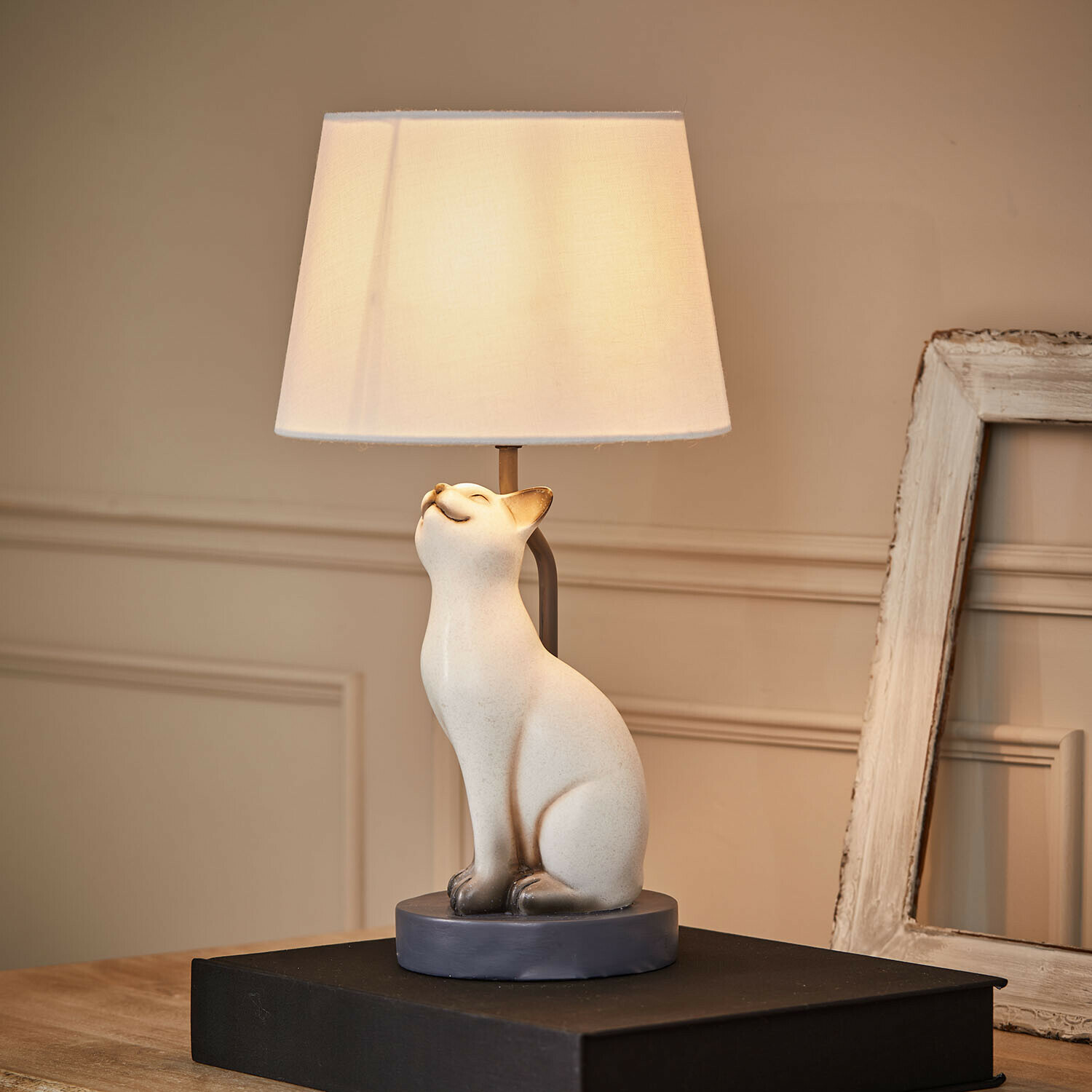 Lampka stołowa z białą ceramiczną podstawą w kształcie kota i kremowym abażurem do salonu