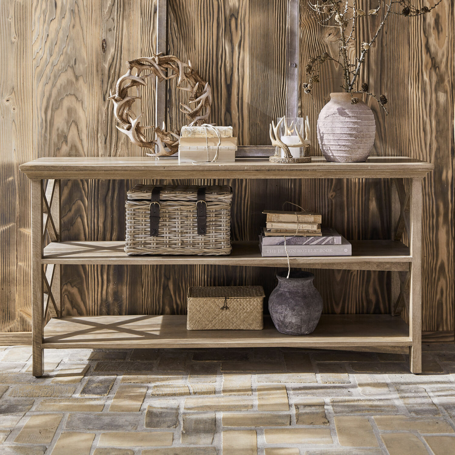Drewniana konsola z dwoma półkami, ozdobiona wiklinowymi koszami i ceramicznymi wazonami w naturalnych kolorach