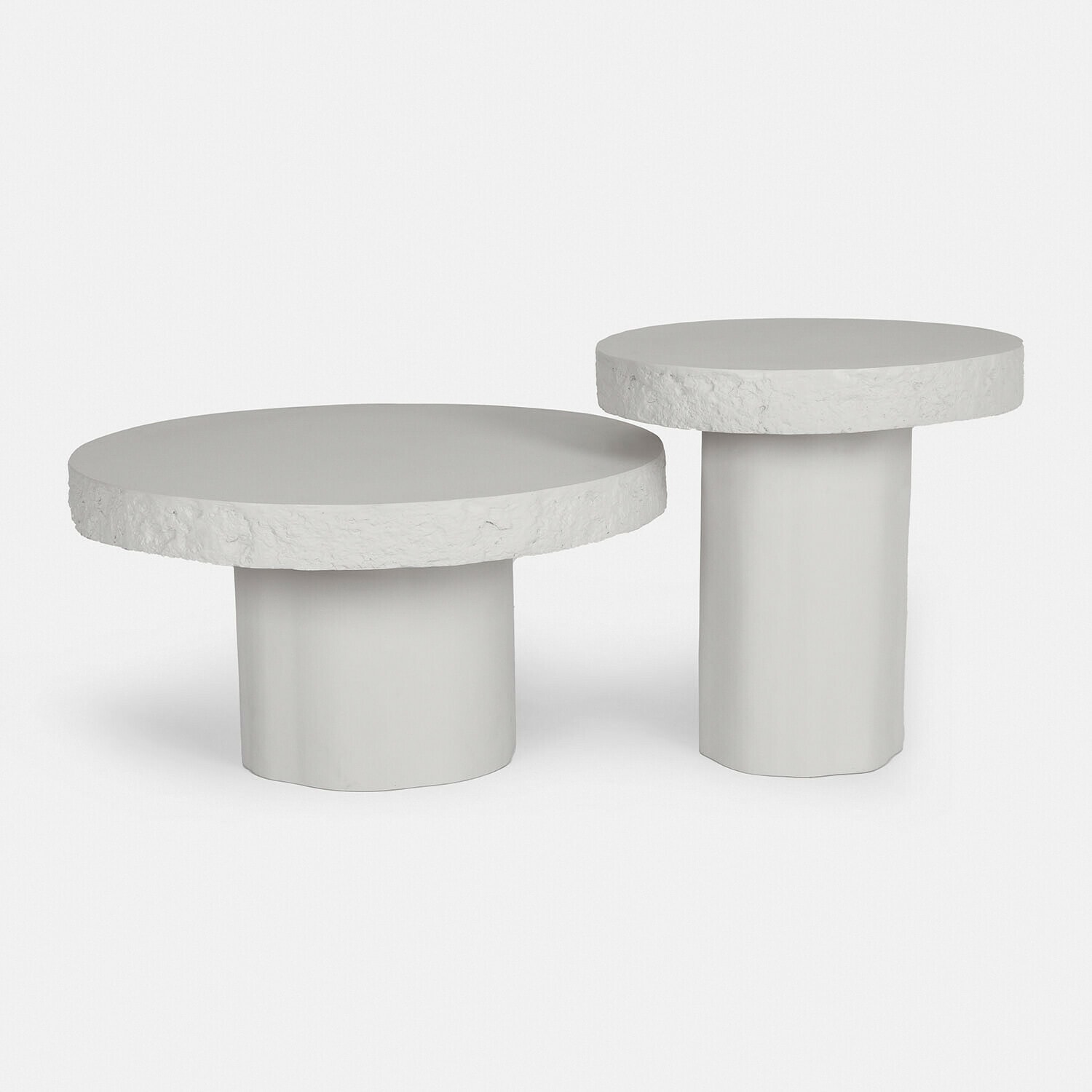 Zestaw dwóch białych stolików kawowych z teksturowanym blatem i cylindryczną podstawą z betonu