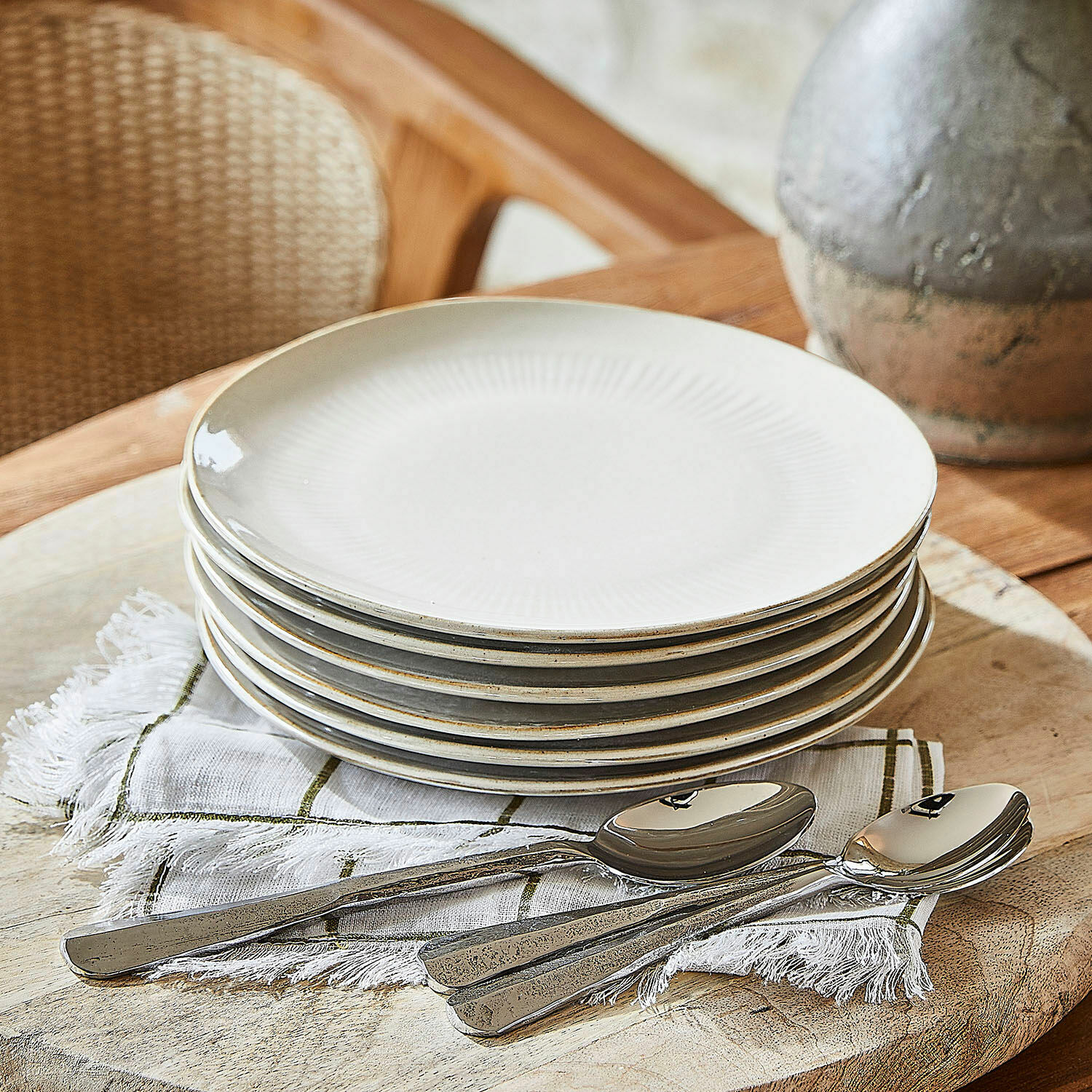 Zestaw 6 talerzy deserowych Périers Zestaw sześciu kremowych ceramicznych talerzy z delikatnym wzorem i metalowe łyżki na lnianej serwetce