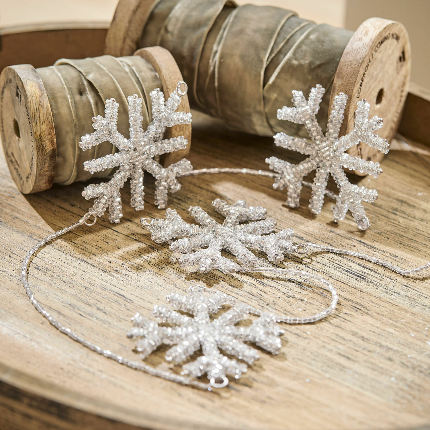 Girlanda Snowflakes Dekoracyjny łańcuch z przezroczystych koralików w kształcie śnieżynek na drewnianej tacy