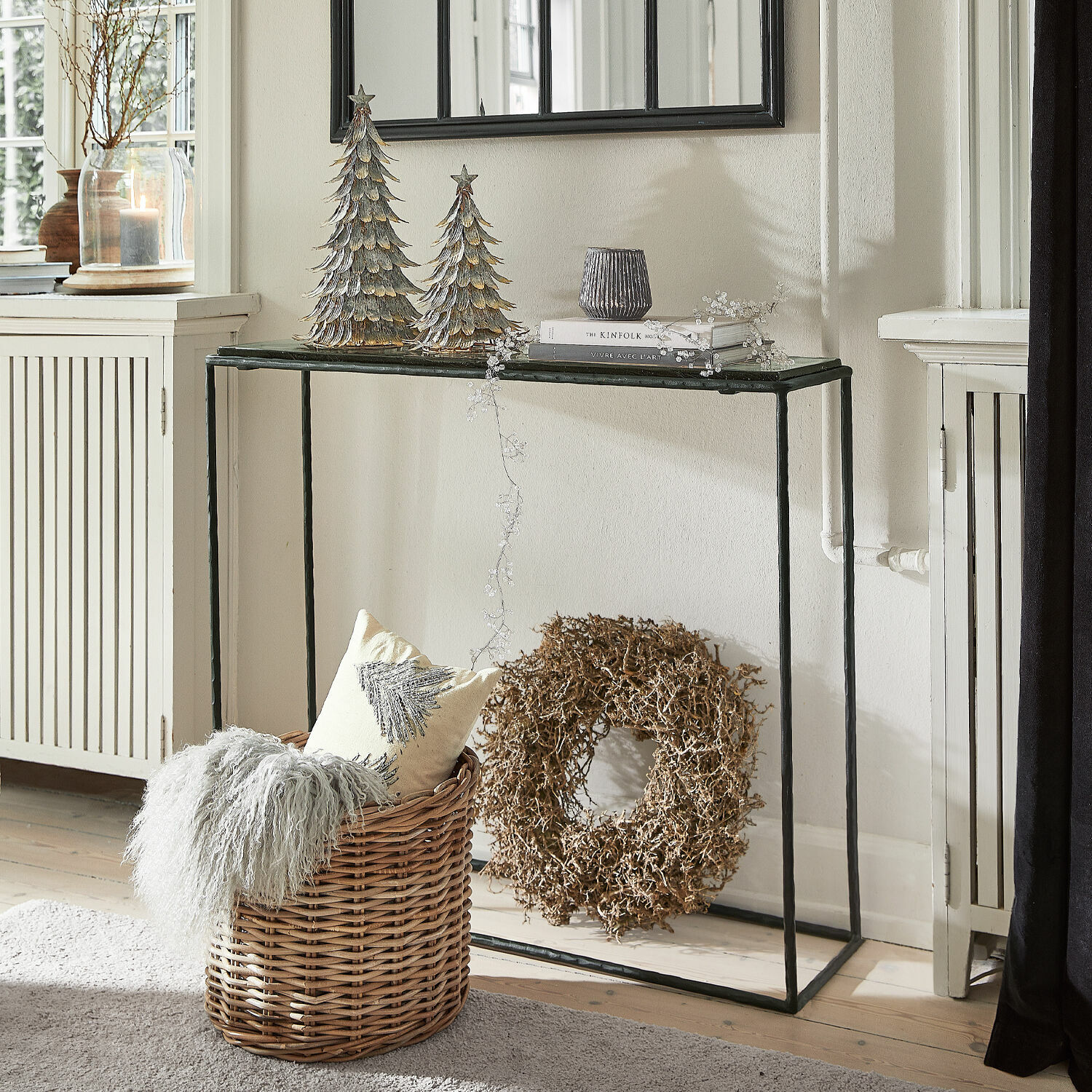 Metalowa konsola z czarnym blatem w stylu loft z dekoracjami świątecznymi i wiklinowym koszem