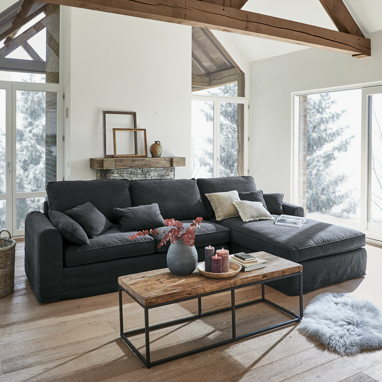 Sofa Seaford Szara narożna sofa z tkaniny w nowoczesnym salonie z drewnianym stolikiem i dużymi oknami