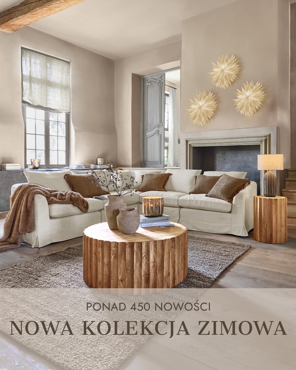 Przytulny salon z beżową sofą, drewnianym stolikiem i dekoracjami w ciepłych odcieniach zimowej kolekcji
