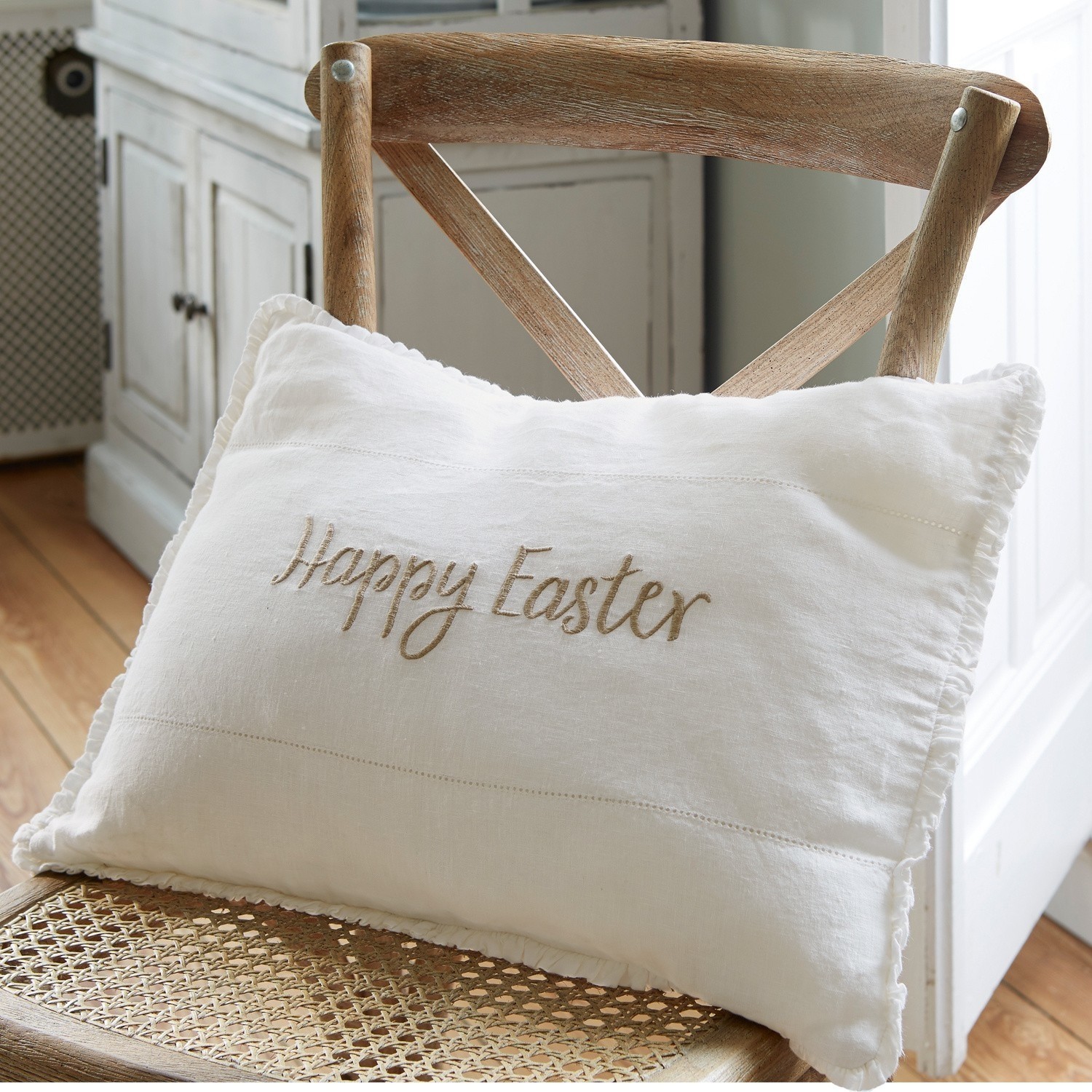 Poduszka Happy Easter Biała lniana poduszka dekoracyjna z haftem Happy Easter na drewnianym krześle, dekoracja wielkanocna