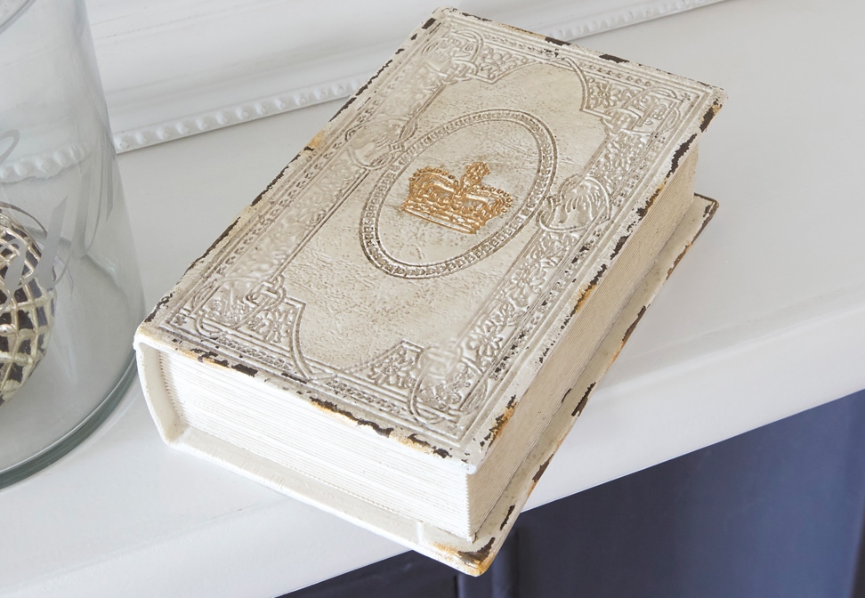 Dekoracyjna książka w stylu shabby chic z białą, postarzaną okładką i złotą koroną