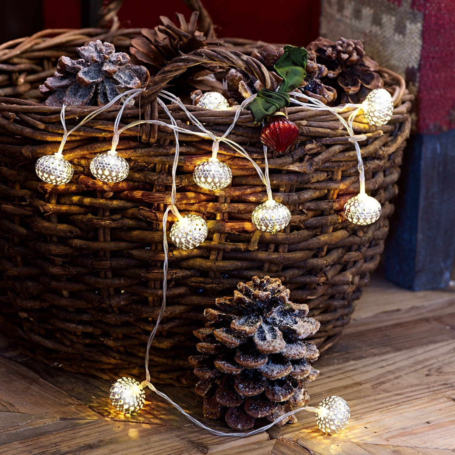 Łańcuch świetlny Fireballs Lampki LED w kształcie szyszek na wiklinowym koszu z naturalnych materiałów, dekoracja świąteczna