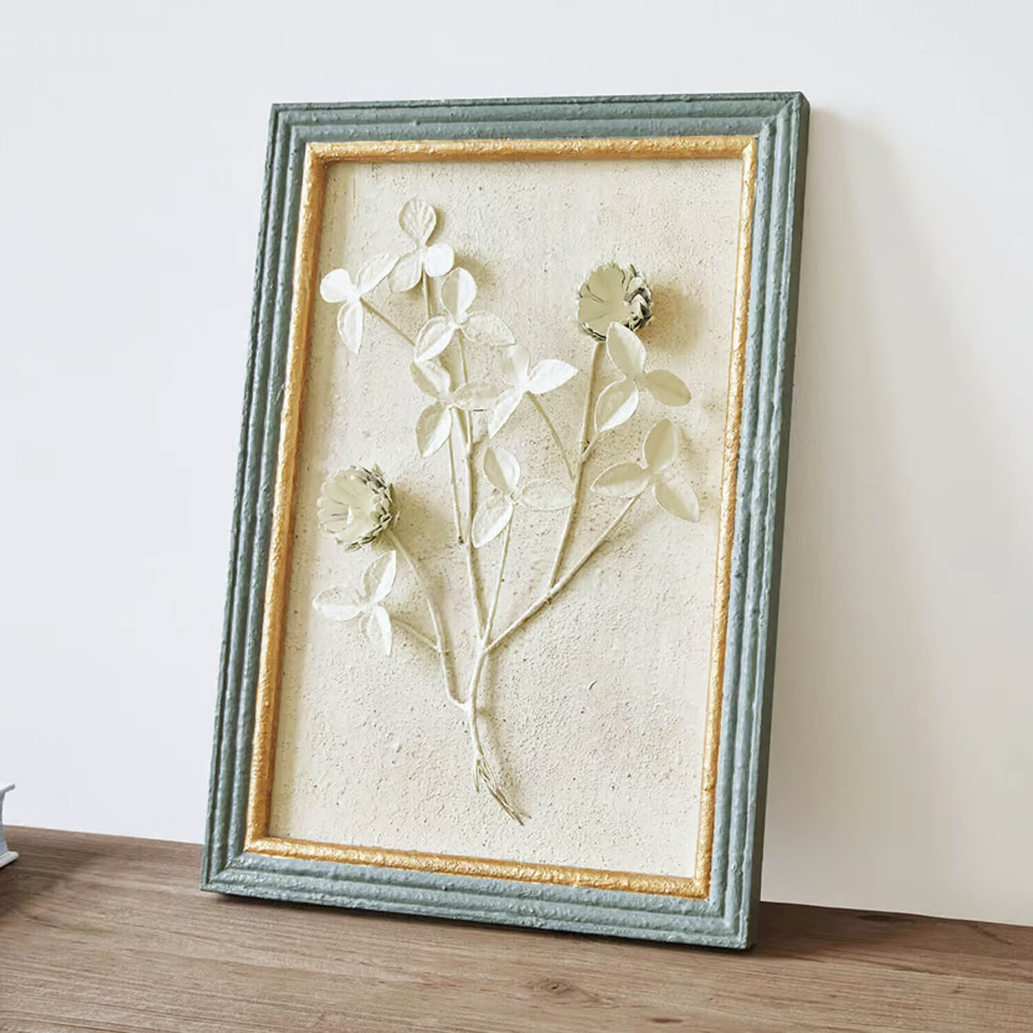 Dekoracyjny relief kwiatowy w ramie z teksturowanego materiału w kolorze zielonym i złotym