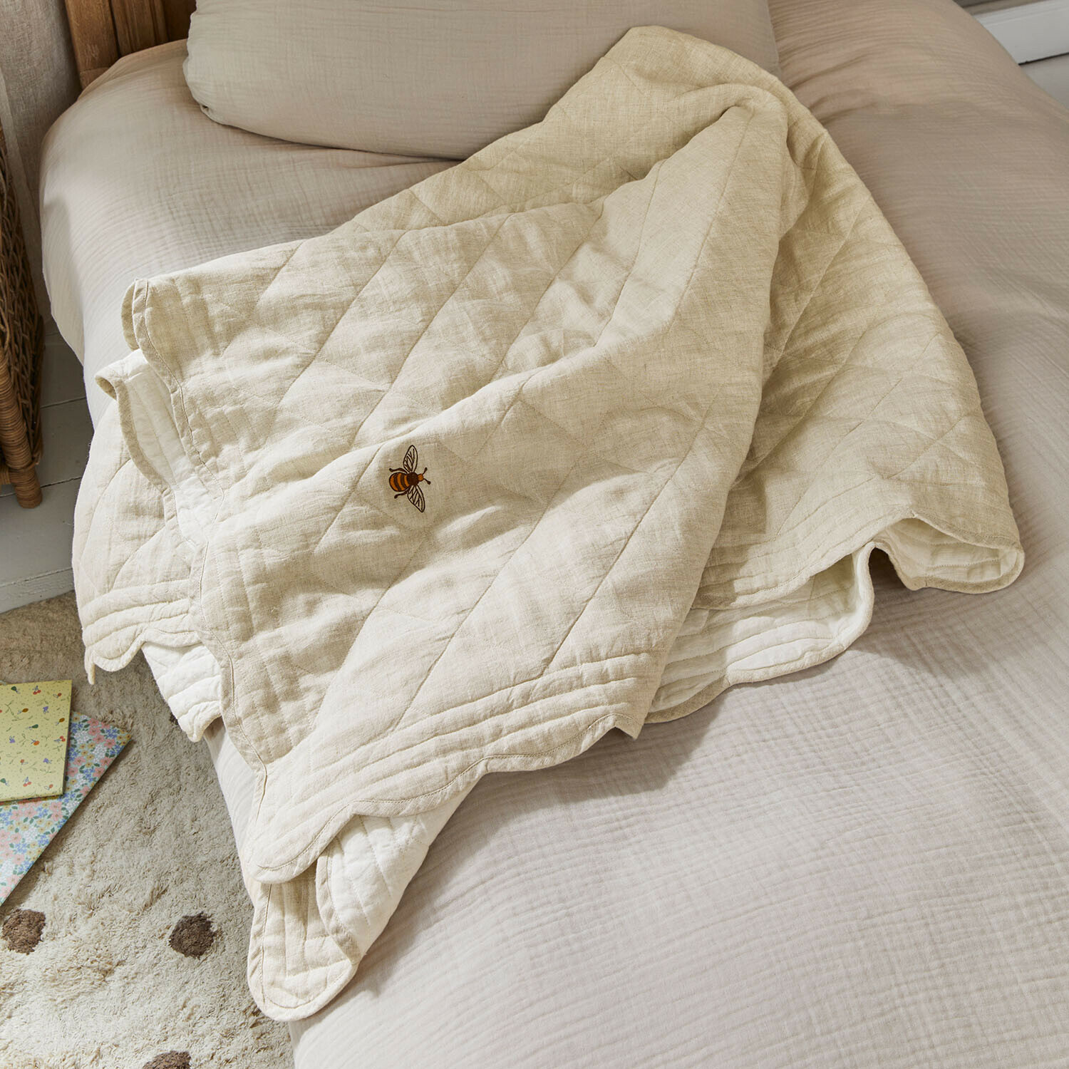 Beżowa pikowana narzuta z haftem pszczoły na łóżku, miękka bawełniana tkanina do sypialni