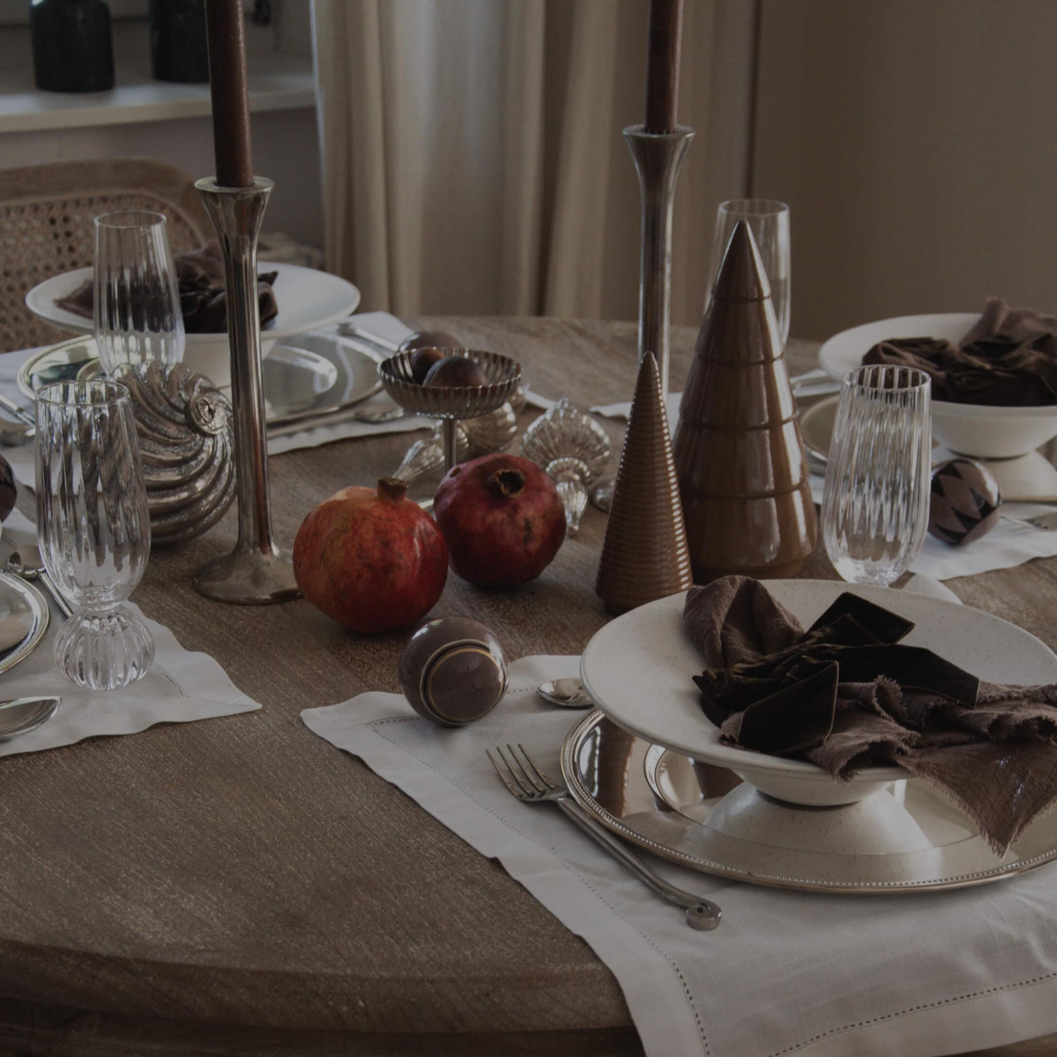 Elegancko nakryty stół z ceramicznymi stożkami, granatowymi serwetkami i granatowymi granatami