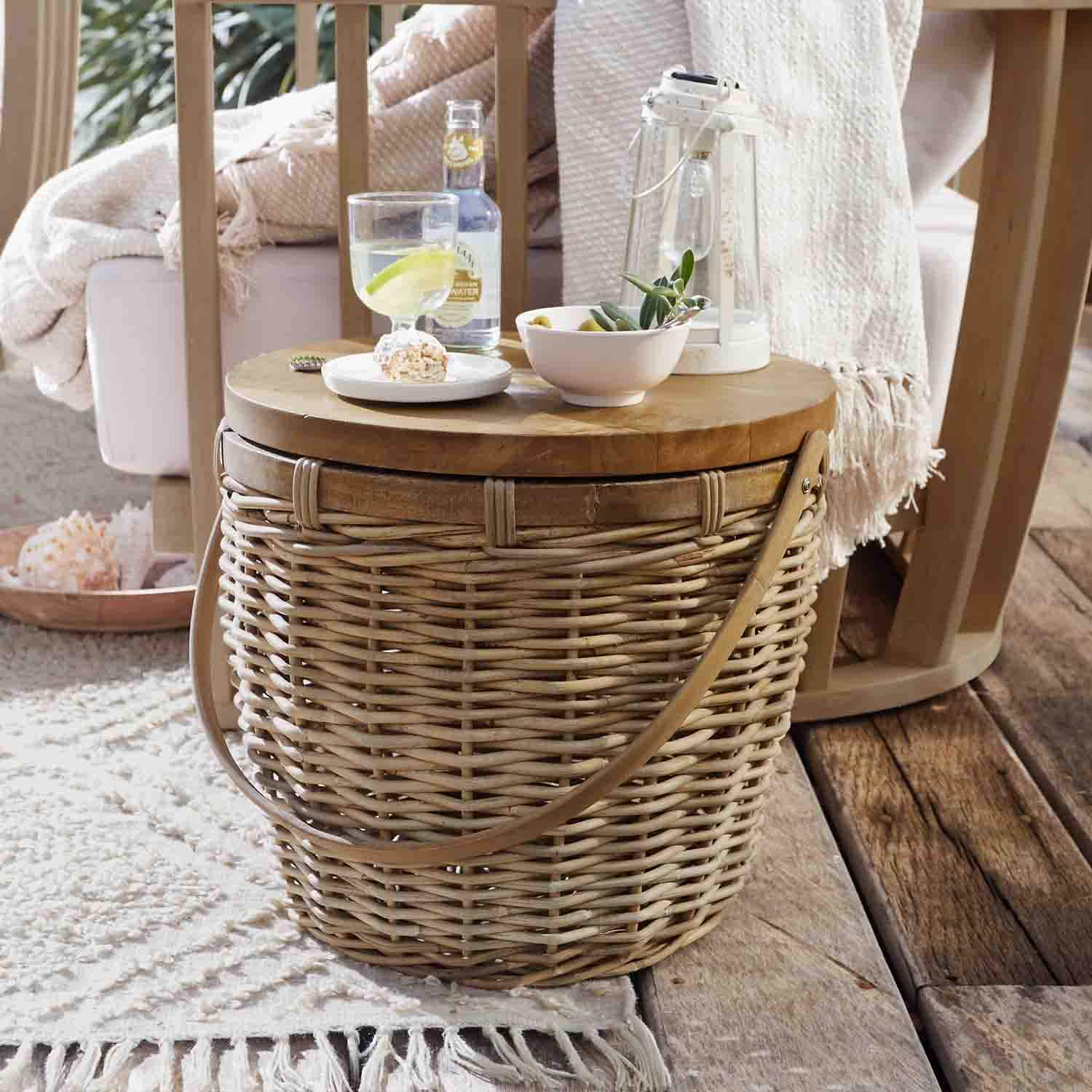 Okrągły stolik z wikliny i drewna w naturalnym kolorze z lampionem i przekąskami na tarasie