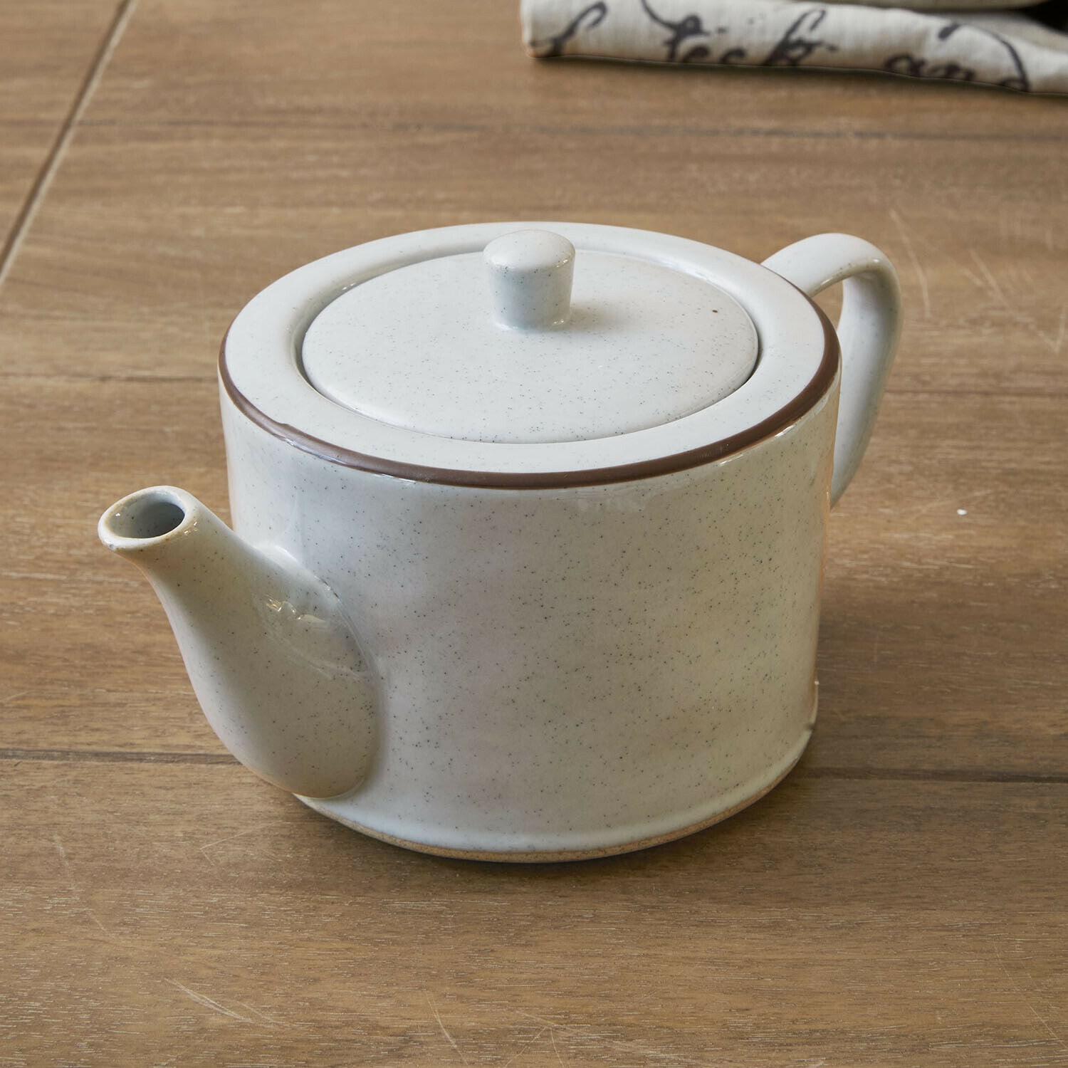 Dzbanek na herbatę Biarré Ceramiczna biała czajniczek z brązową obwódką na drewnianym stole do parzenia herbaty
