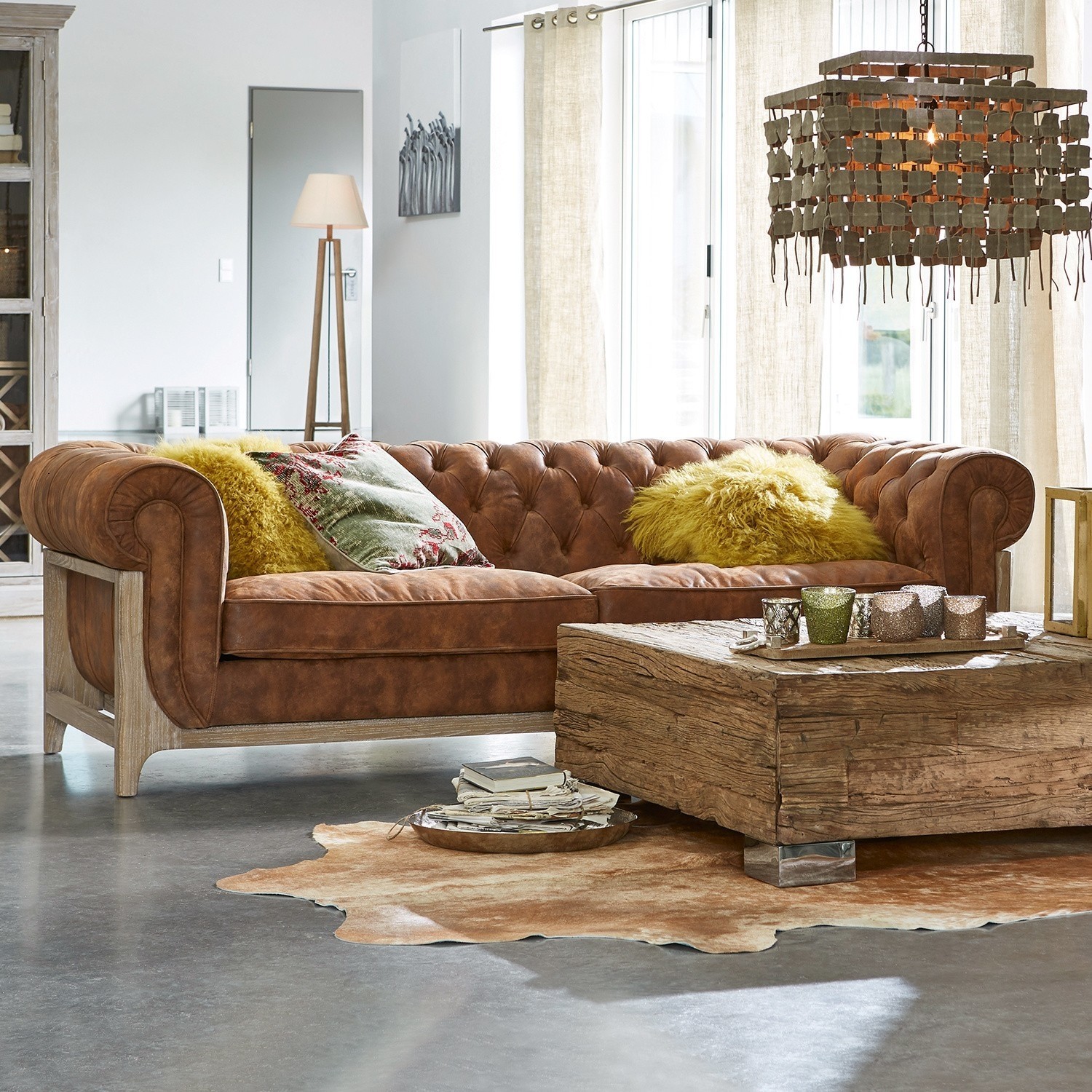 Sofa Swansboro Brązowa skórzana sofa Chesterfield z drewnianą ramą i żółtymi poduszkami w nowoczesnym salonie