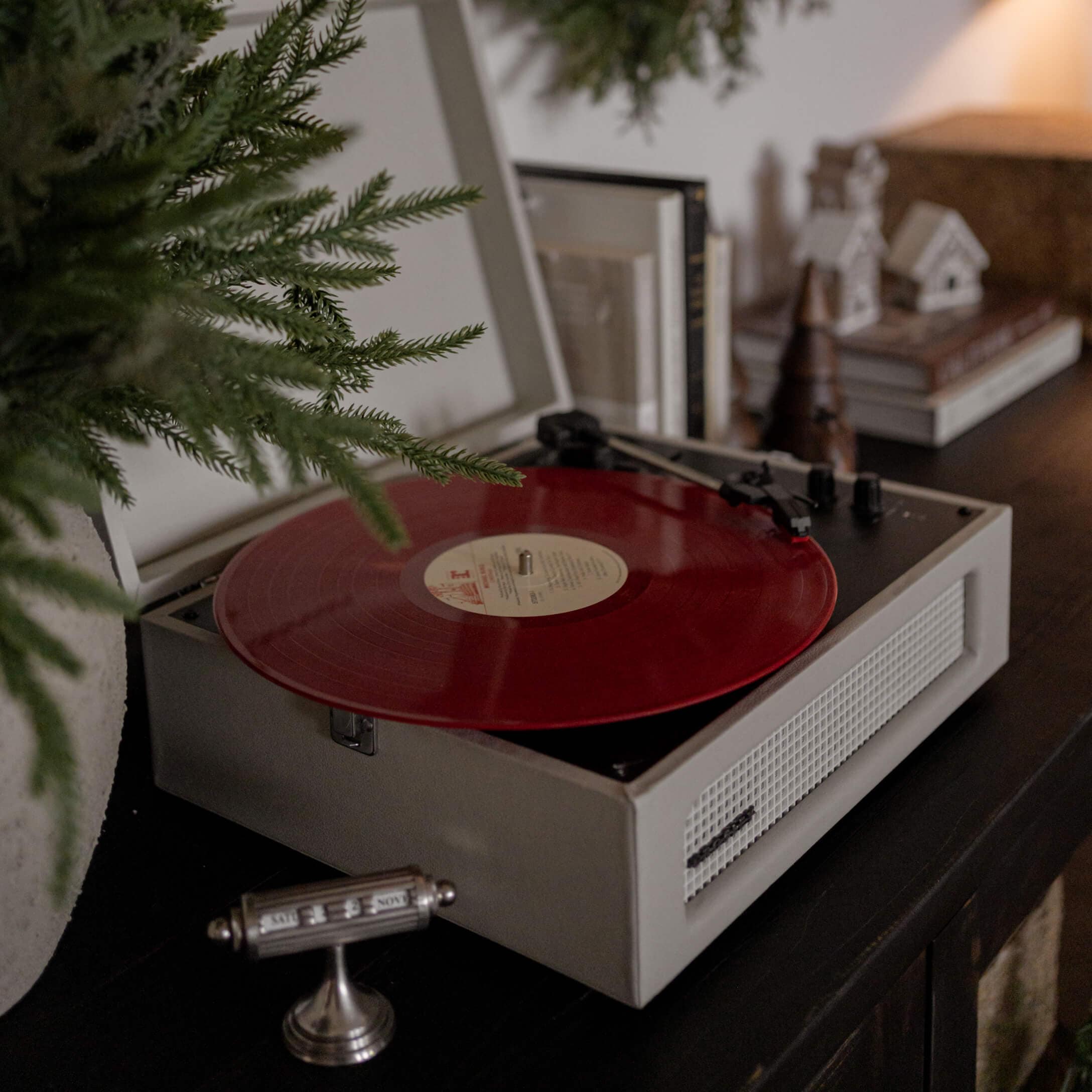 Gramofon w stylu retro z czerwonym winylowym płytą na ciemnym meblu w przytulnym wnętrzu