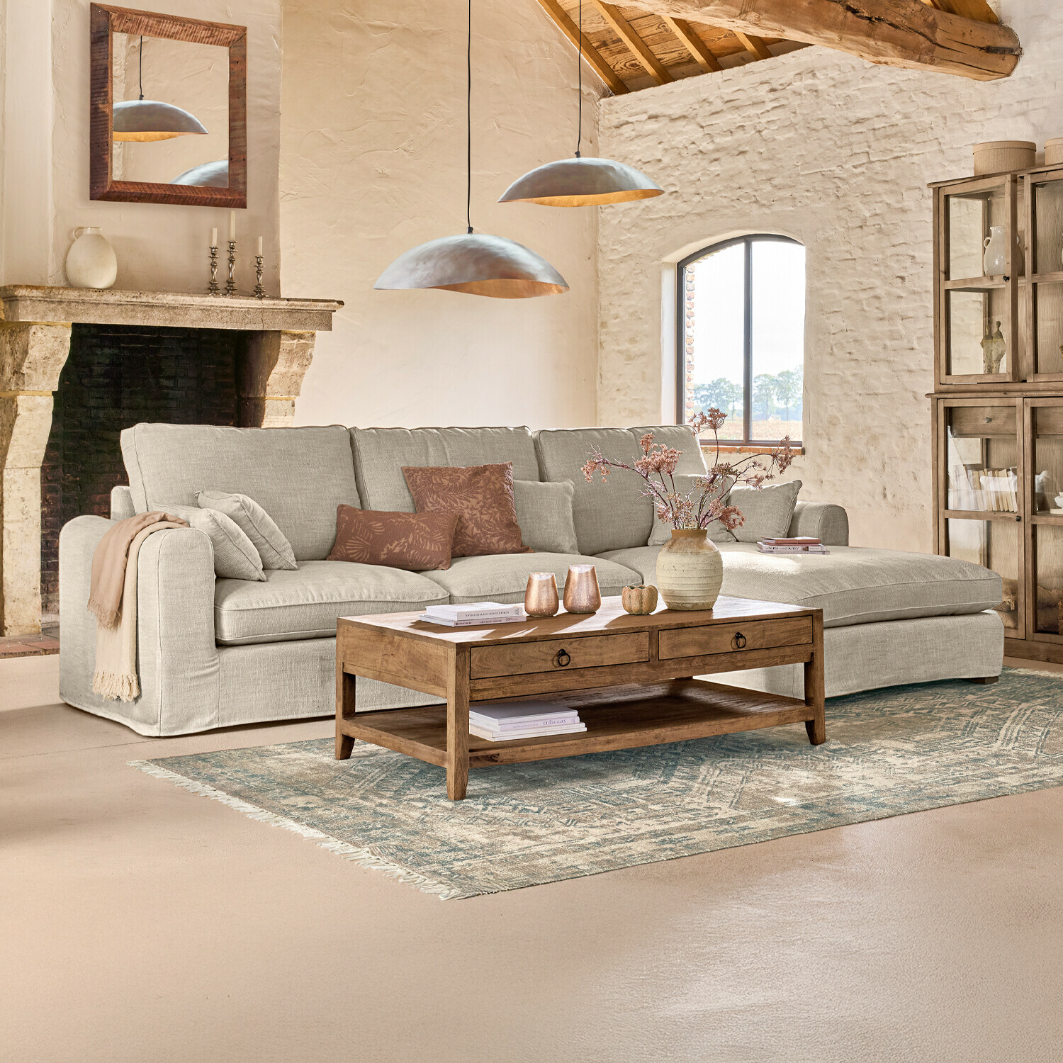 Sofa Seaford Przytulny salon z beżową tkaninową sofą narożną i drewnianym stolikiem kawowym na dywanie