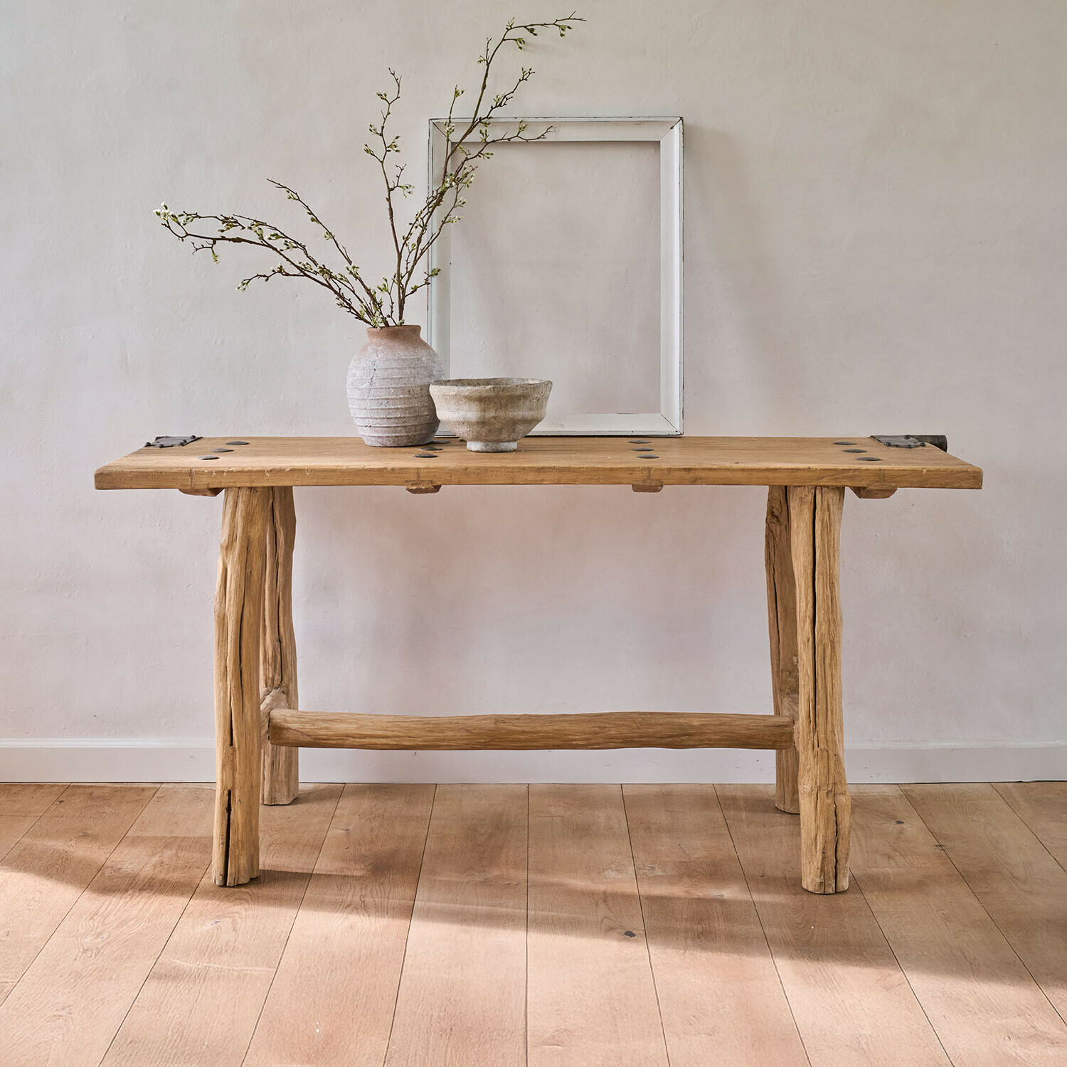 Konsola Crestmoore Rustykalny drewniany stół z naturalnego drewna z ceramiczną wazą i miską na jasnym tle, meble drewniane