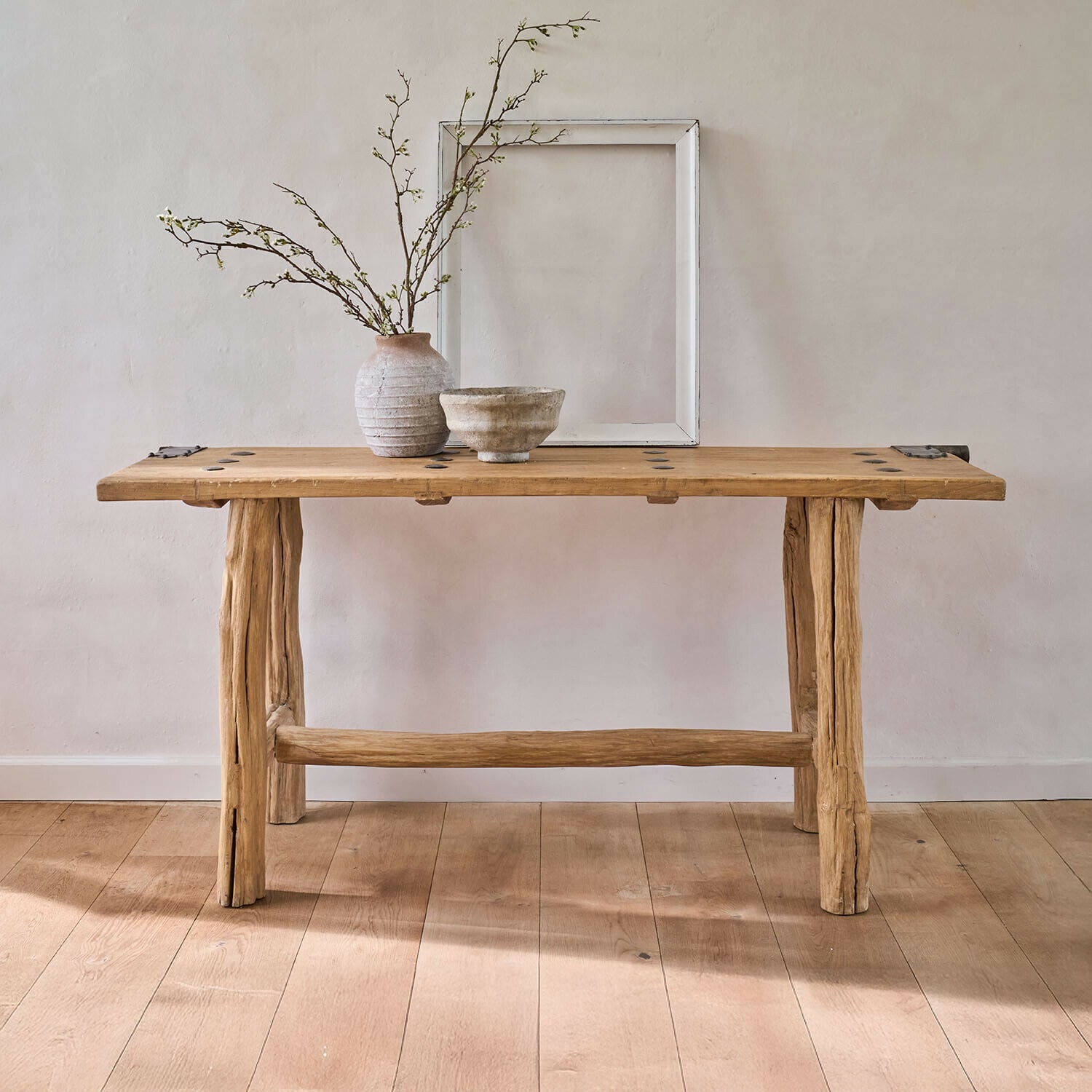 Konsola Crestmoore Rustykalny drewniany stół z naturalnego drewna z ceramiczną wazą i miską na jasnym tle, meble drewniane