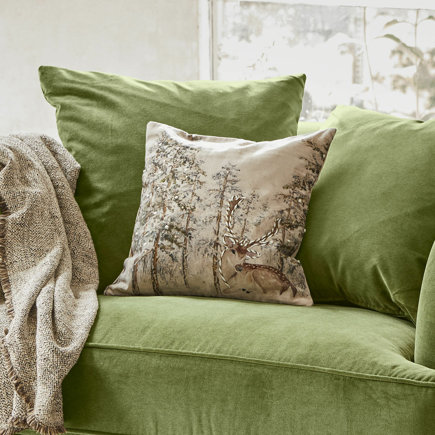 Poszewka na poduszkę Valoisin Zielona aksamitna sofa z dekoracyjną poduszką z nadrukiem jelenia i beżowym kocem do salonu