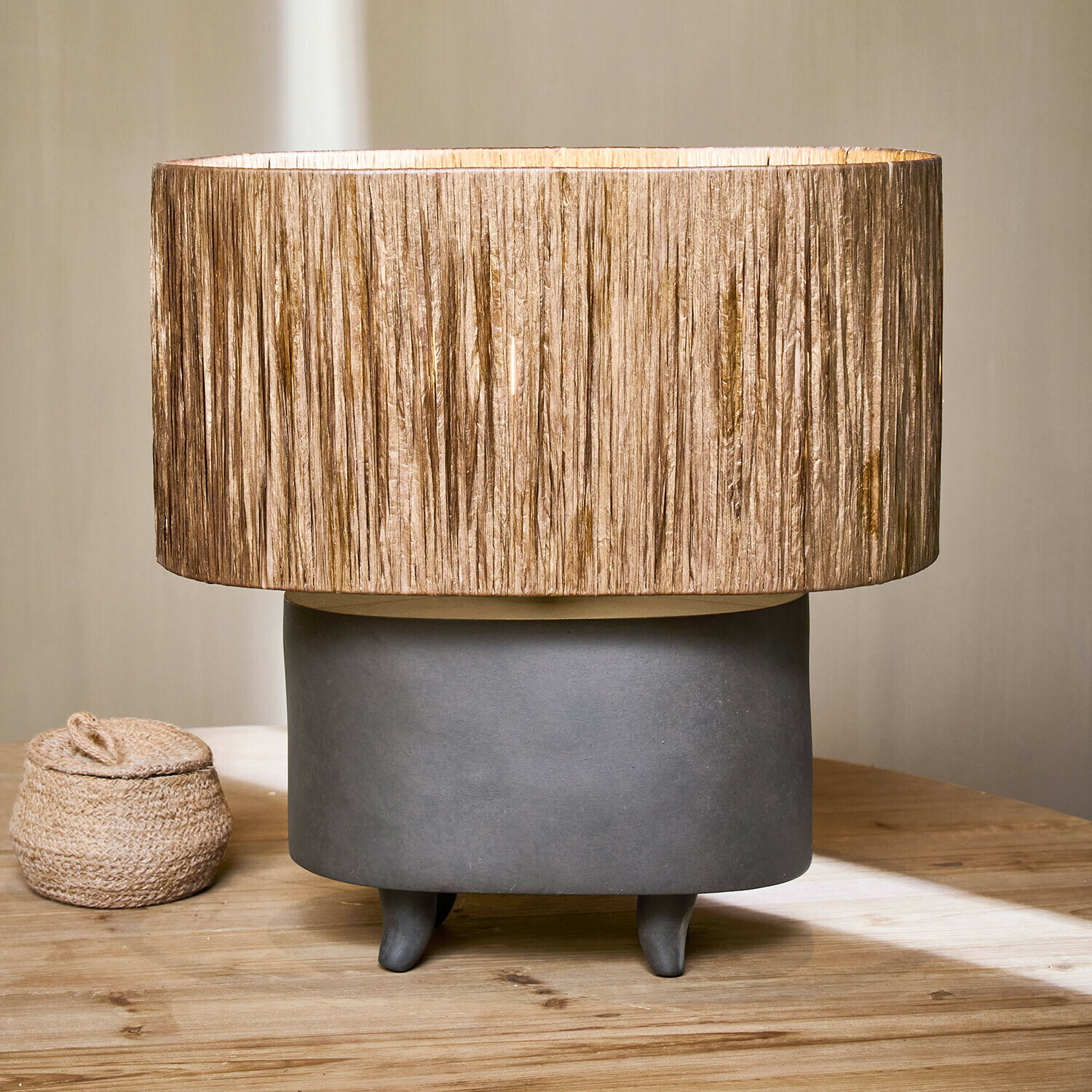Lampka stołowa z szarą ceramiczną podstawą i beżowym abażurem z naturalnego materiału, dekoracja wnętrz