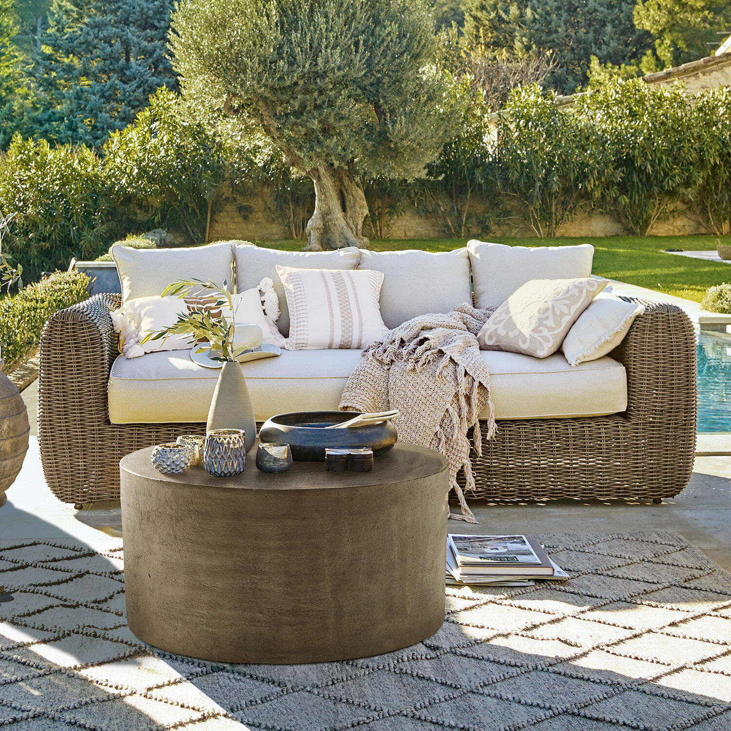 Sofa Bogdanne Sofa ogrodowe z rattanu w kolorze beżowym z poduszkami i okrągłym betonowym stolikiem kawowym