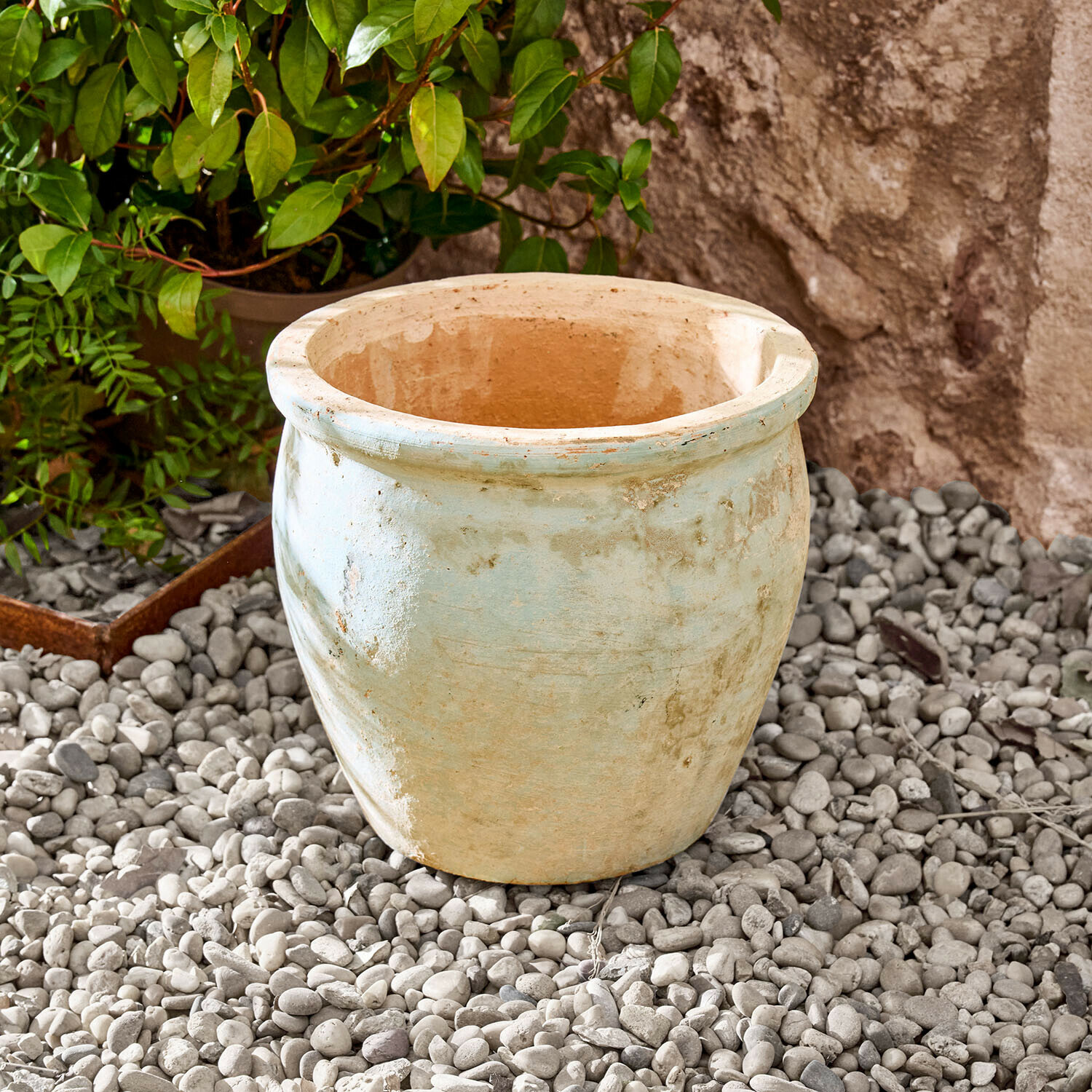 Osłonka doniczki Naldorín Duży ceramiczny doniczka w jasnobeżowym kolorze na kamiennym podłożu do ogrodu
