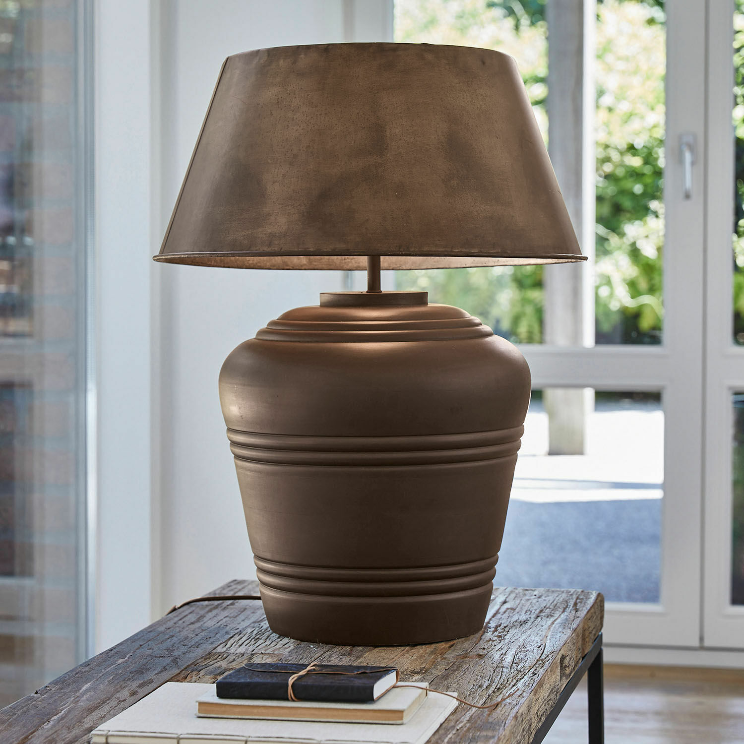 Lampa stołowa Morice Brązowa ceramiczna lampa stołowa z abażurem na drewnianym stole w jasnym wnętrzu